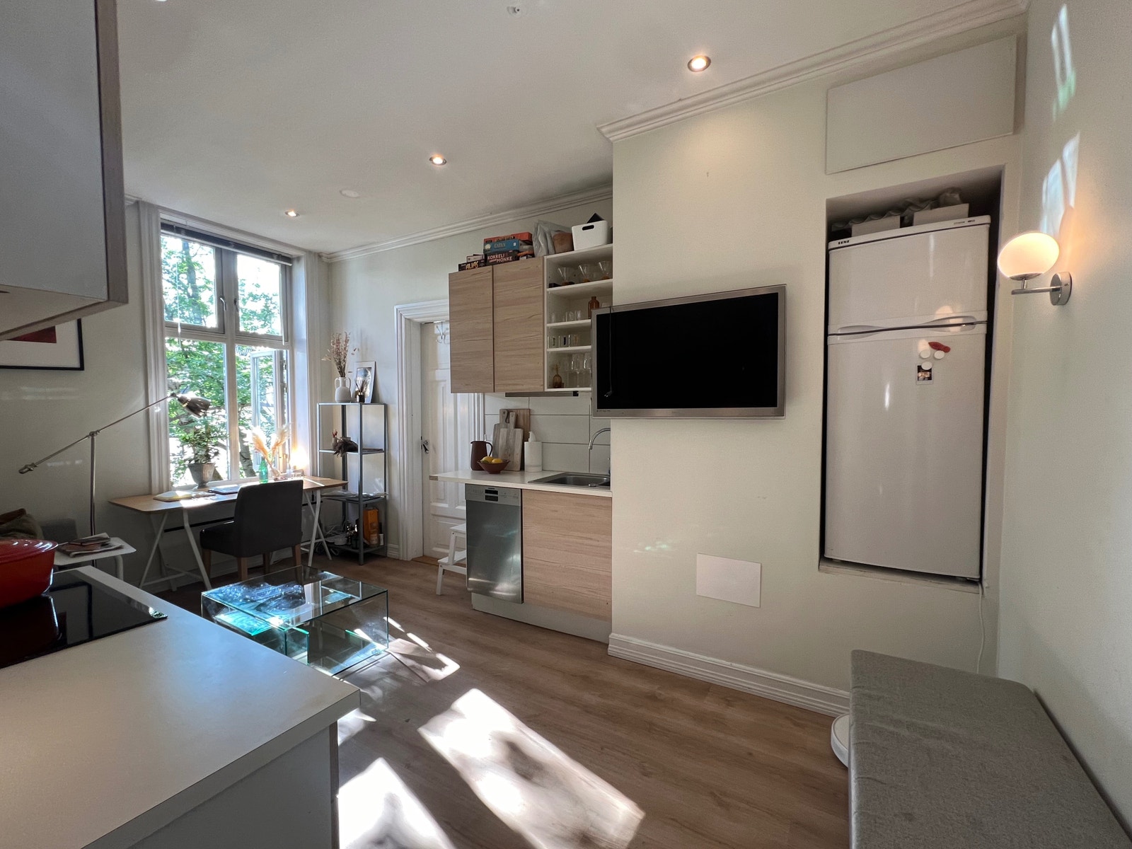 God plassutnyttelse med kjøl/fryser i eget avlukke, TV henger på vegg. Kjøkken med oppvaskmaskin, plass til kopper/tallerkener. Galleribilde
