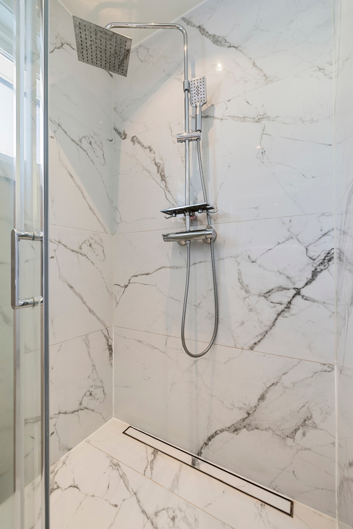 Det er et romslig dusjhjørne og flotte fliser i storformat. Galleribilde