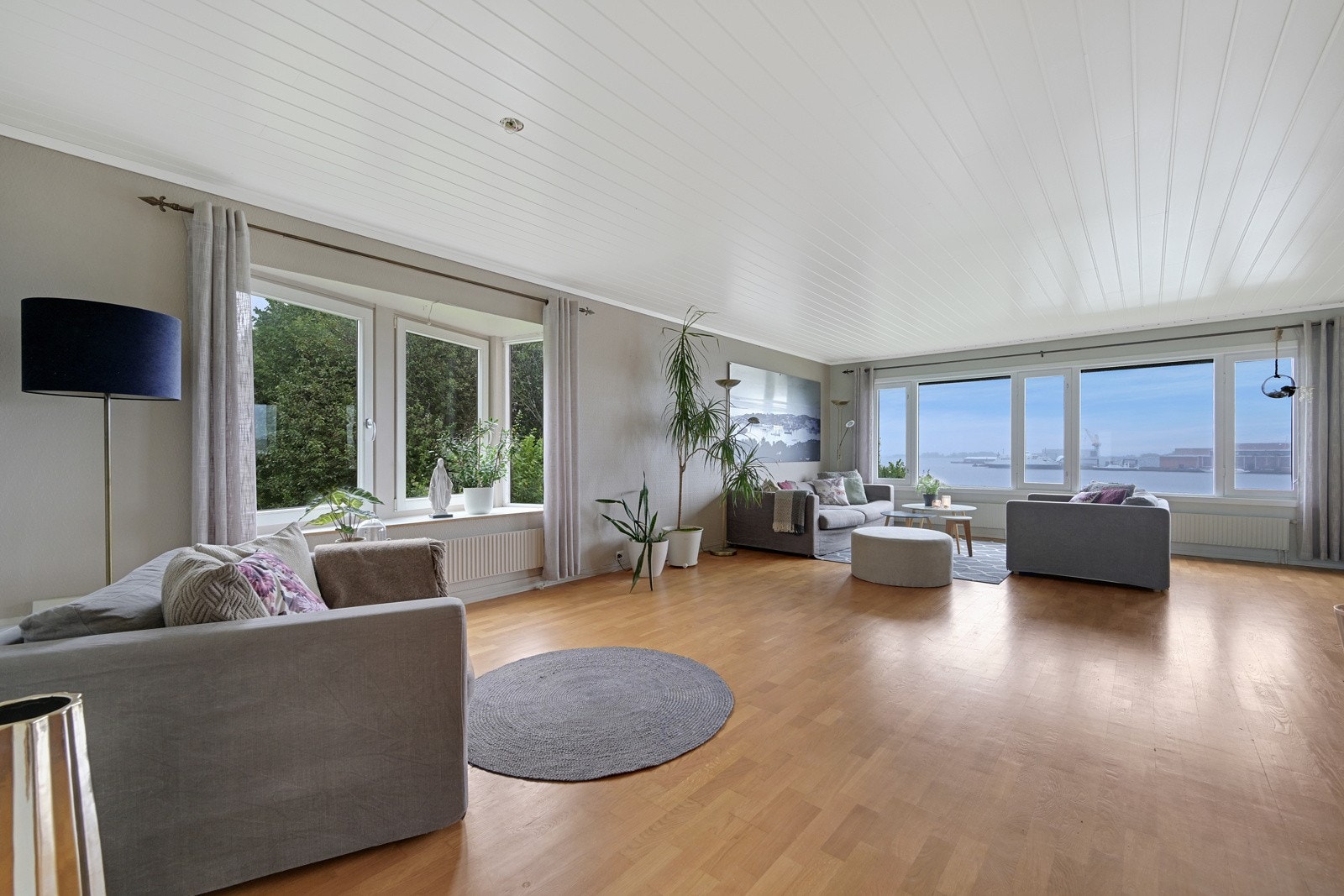 Store vindusflater i stua og god plass for flere sofaer Galleribilde