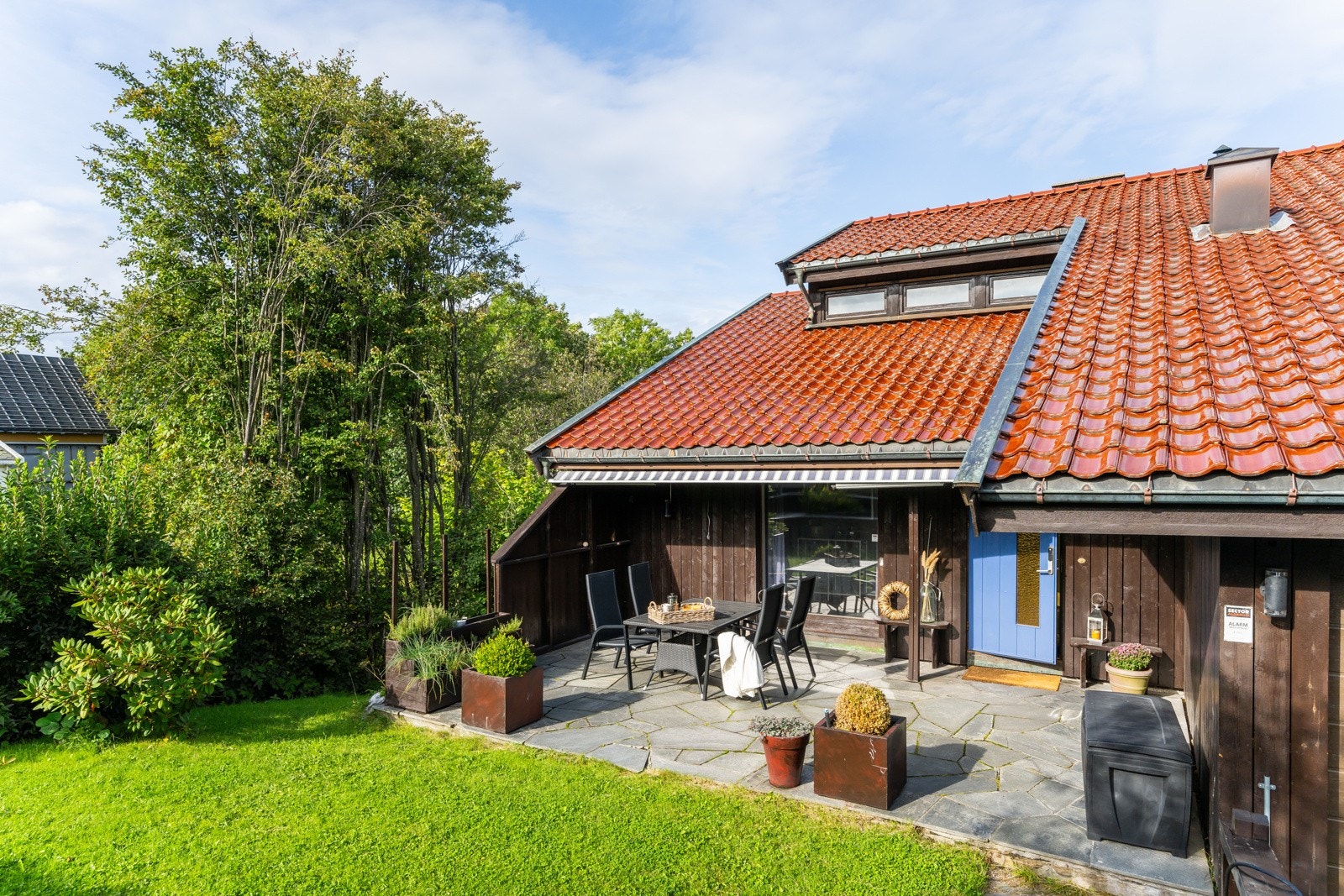 Her ser vi litt av terrassen og den blå inngangsdøren til høyre Galleribilde