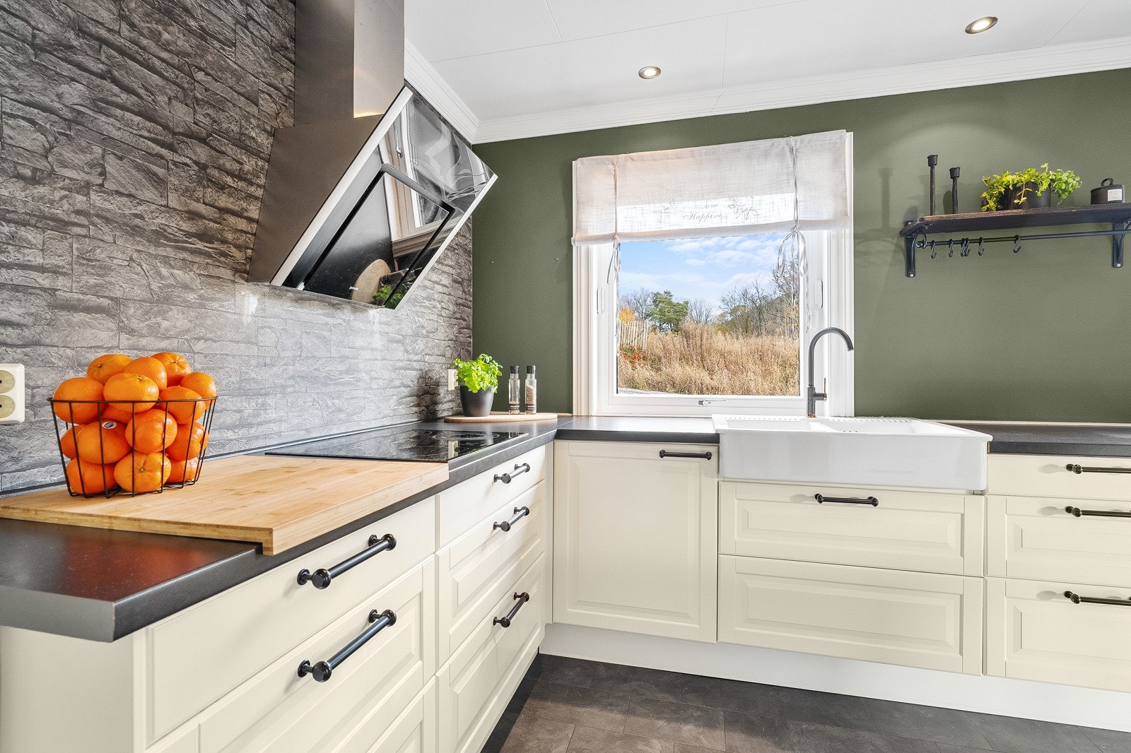 Lekkert kjøkken fra 2013. Klassisk design med lyse fronter, mørke benkeplater og stilren steinlook på vegg. Galleribilde