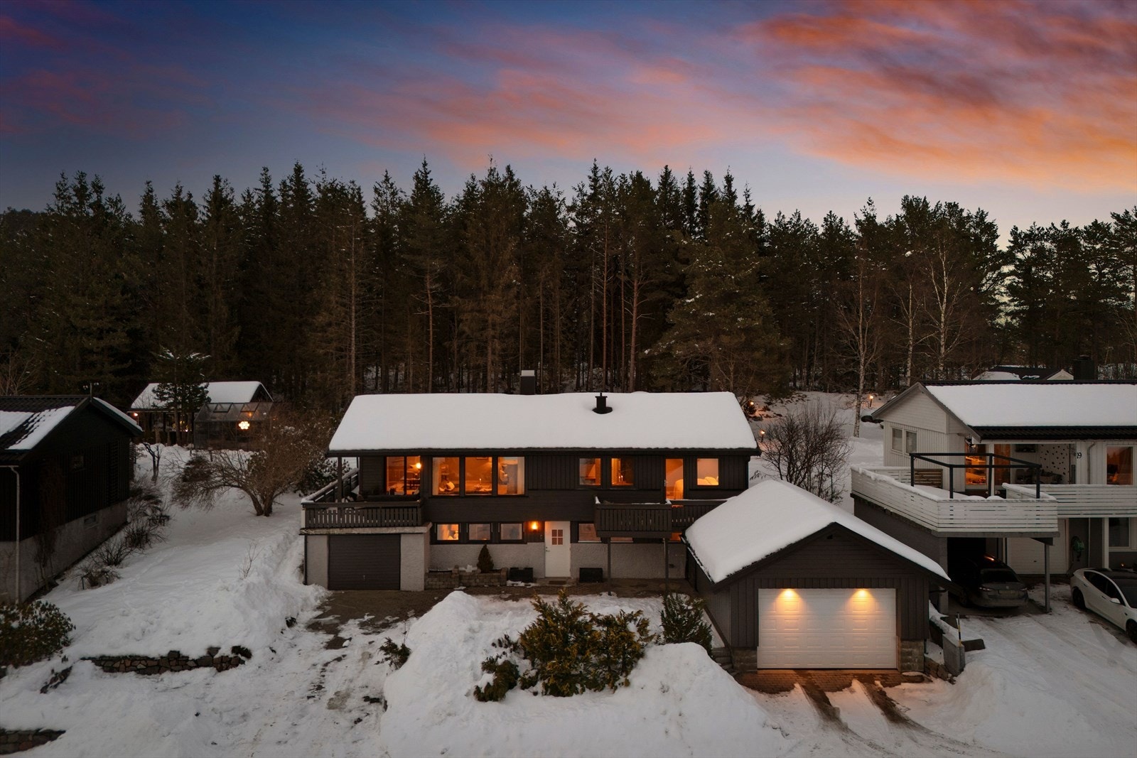 Eiendommen har to garasjer i tillegg til oppstillingsplasser på tomten. Den nyeste av de to garasjene har innlagt elbillader. Galleribilde