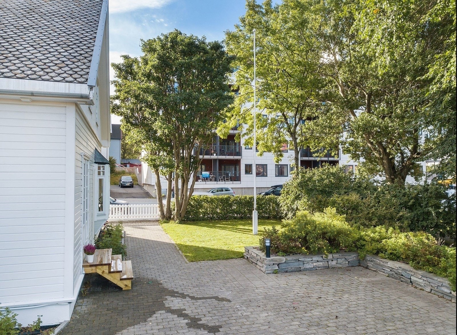 Det er gjennomtenkt beplantning med både trær, hekk og blomsterbed - En liten privat oase "midt" i sentrum Galleribilde