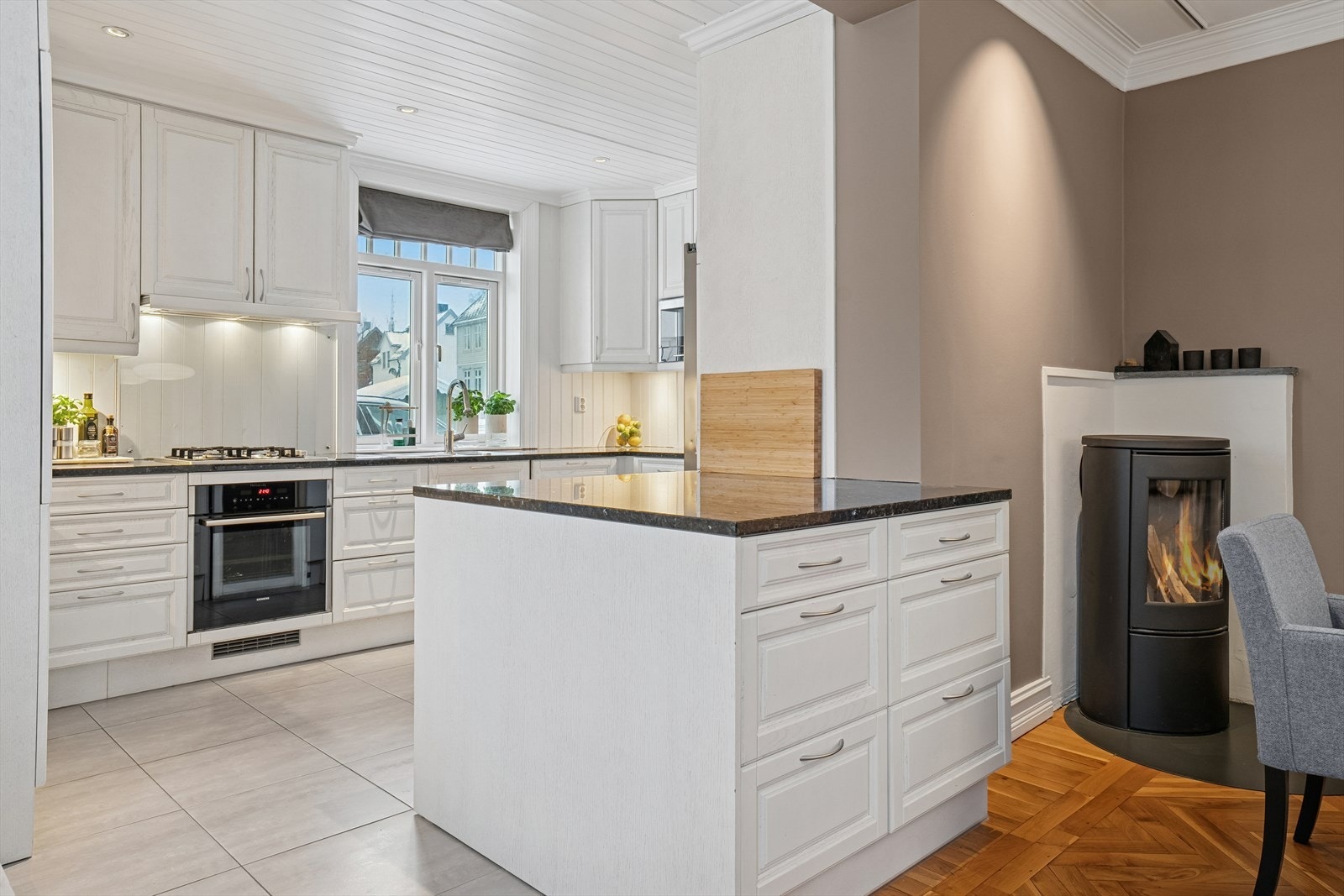 Kjøkkenet har en klassisk innredning (oppgradert i ca. 2013) med takhøye overskap, profilerte fronter og benkeplate i granittstein - Kjøkkenøyen gir ekstra skap- og benkeplass Galleribilde