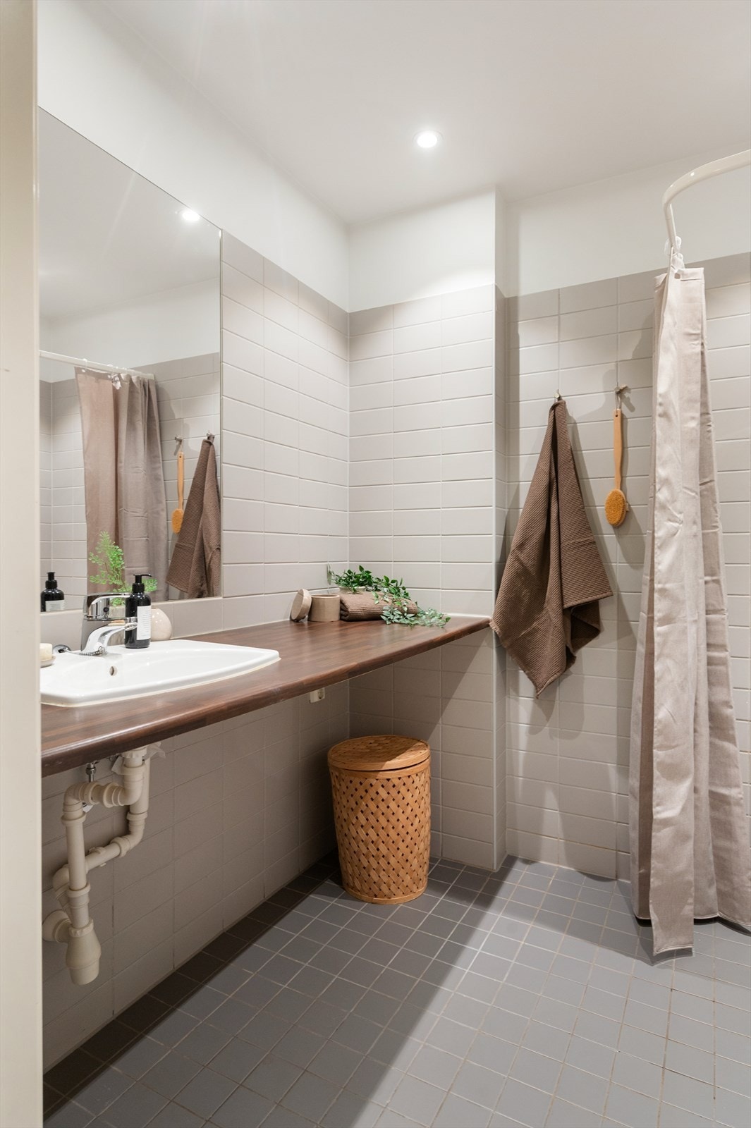 Ellers er det gulvstående toalett og benkeplate i laminat med nedfelt servant. Over servanten er det innfelt speil og belysning med stikkontakt på vegg. Galleribilde