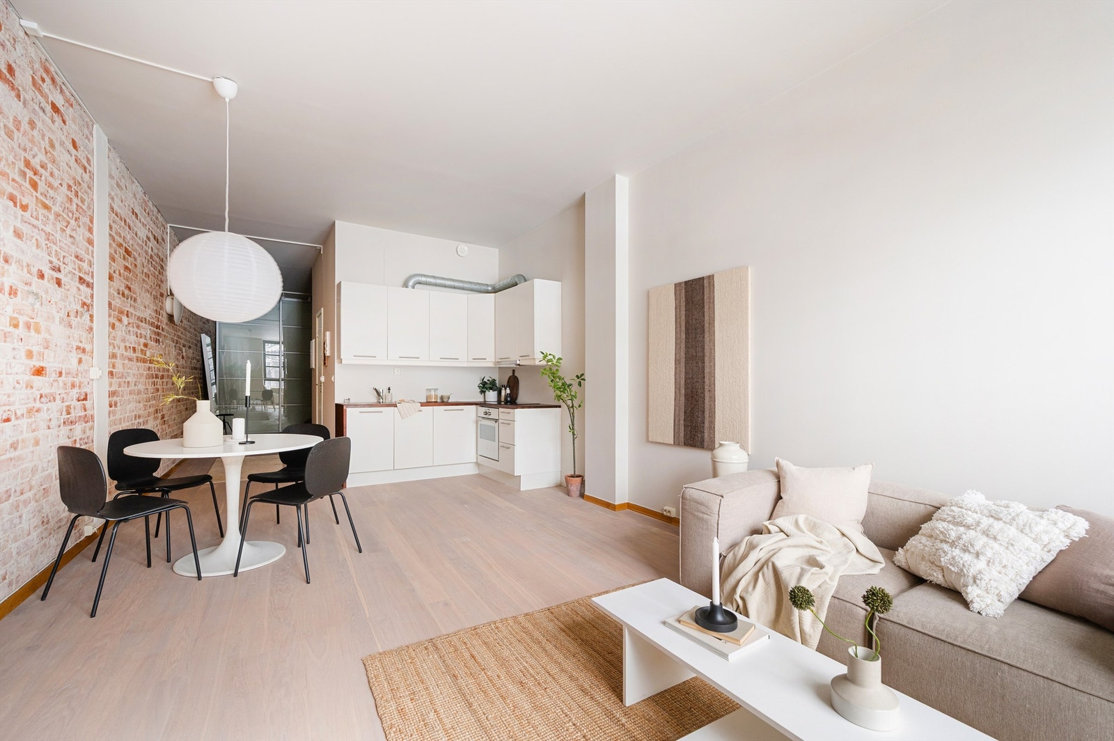 Kjøkkenet er utstyrt med glatte fronter og benkeplate av heltre. Det er nedfelt oppvaskkum i rustfritt stål med ett-greps armatur i tillegg til integrert oppvaskmaskin, stekeovn og induksjonstopp. Platetoppen er ny i 2023. Galleribilde