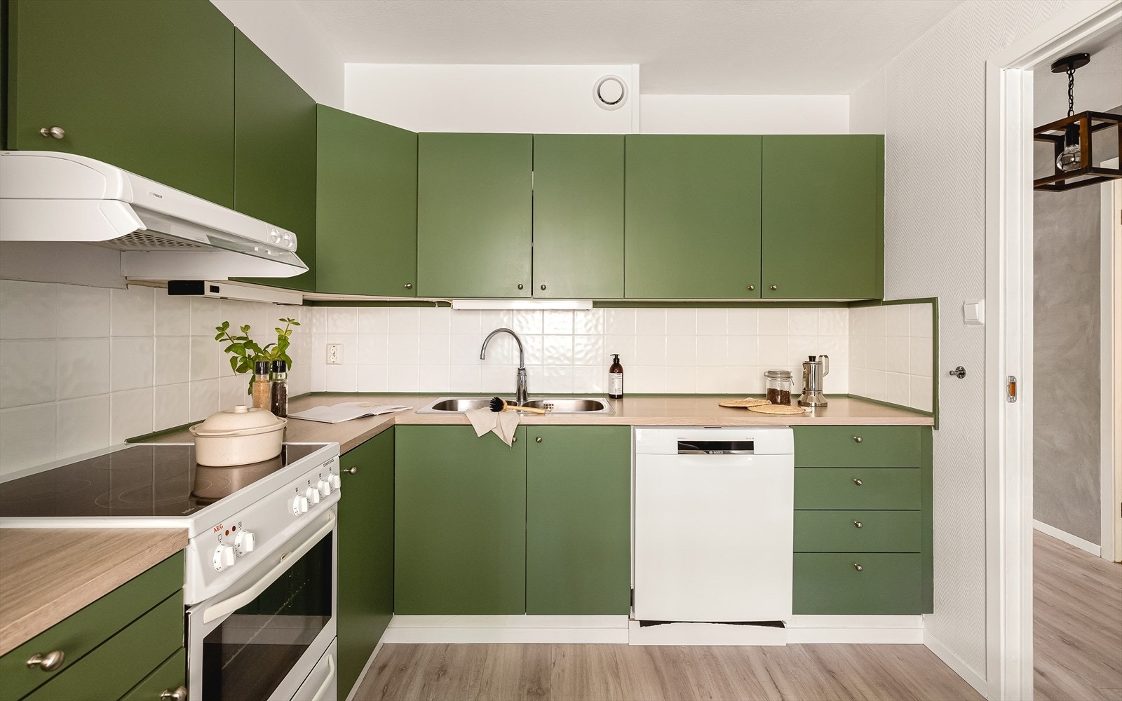 Kjøkkeninnredningen har stilrene, glatte fronter som gir et moderne uttrykk, og flislagt vegg mellom benkeplate og overskap gjør det både praktisk og lettstelt. Galleribilde