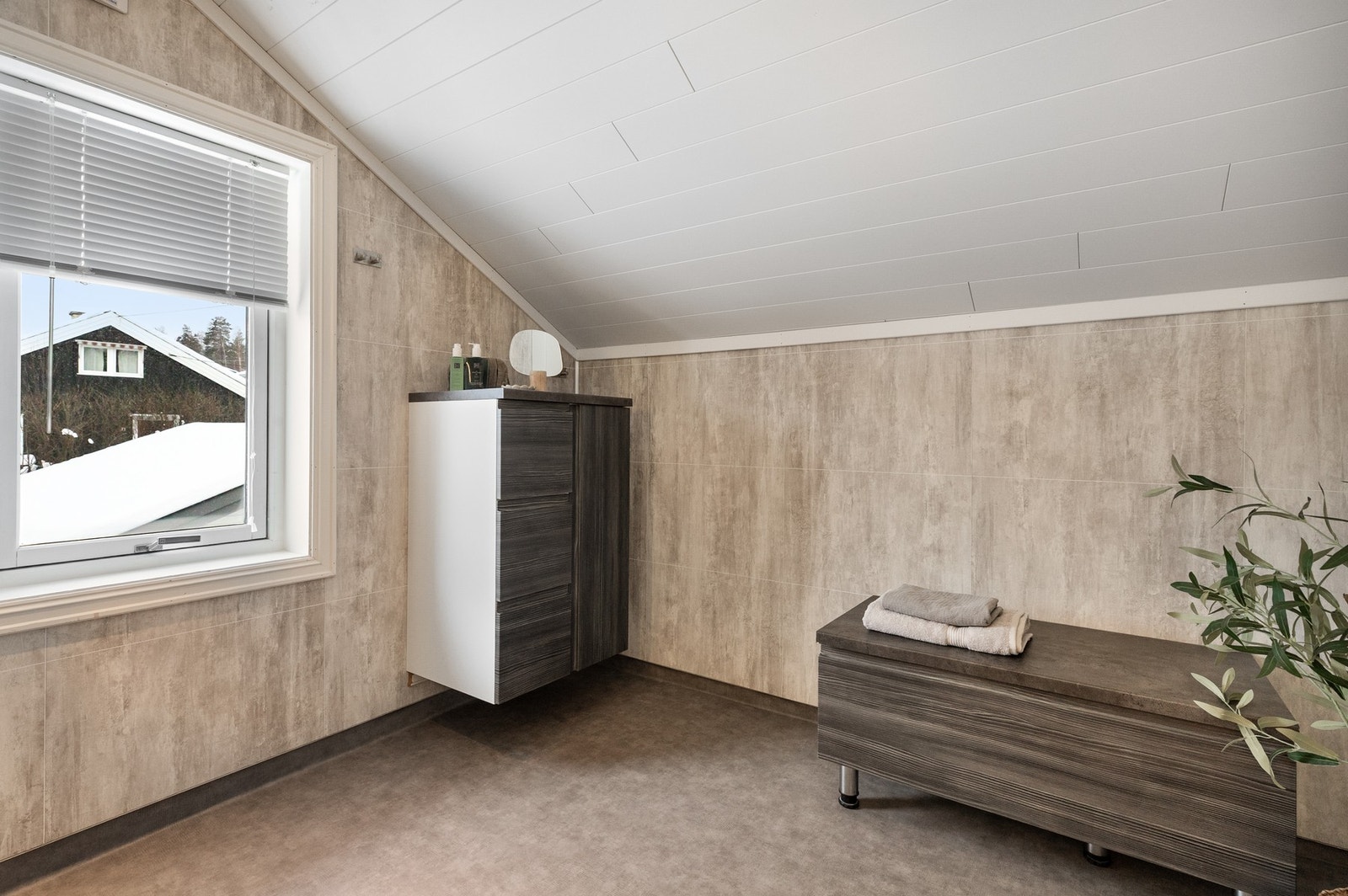 Badet har gulvmontert klosett, delikat baderomsinnredning med heldekkende servantplate Galleribilde