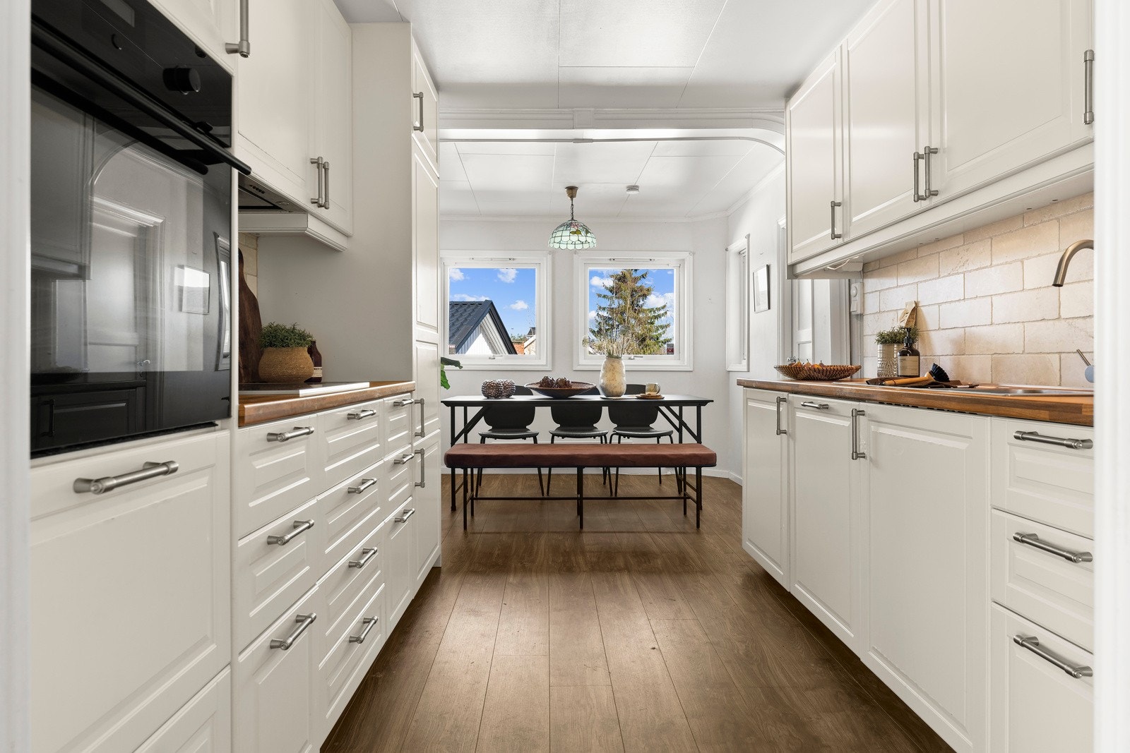 Kjøkkenet ligger i eget rom, tilknyttet stuen. Kjøkkeninnredningen er utført med profilerte fronter, laminat benkeplate og fliser over benk. Galleribilde