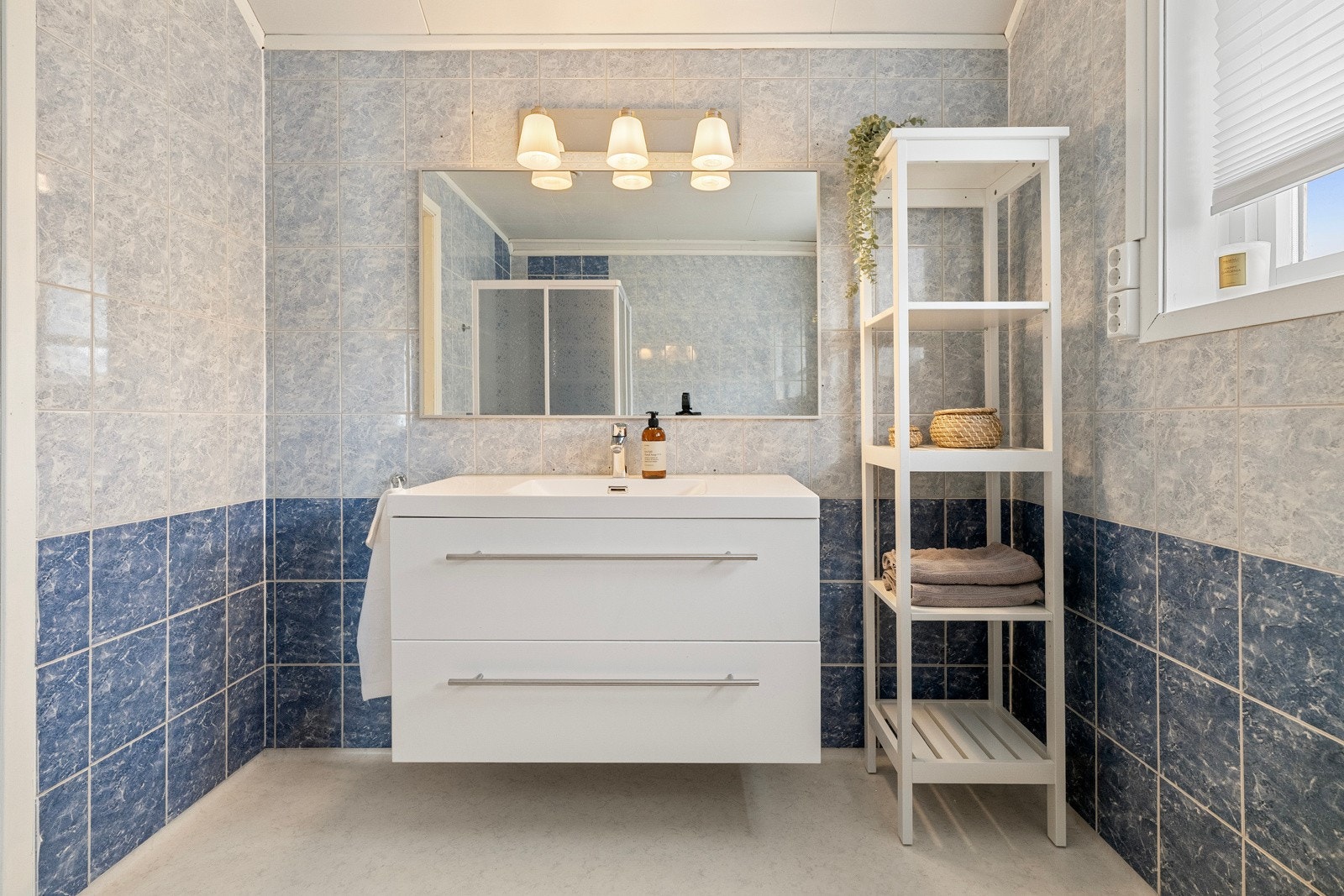 Badet i tredje etasje har flislagte vegger, himlingsplater i tak og vinylbelegg på gulvet, og er innredet med dusjhjørne, toalett og nedfelt servant. Galleribilde