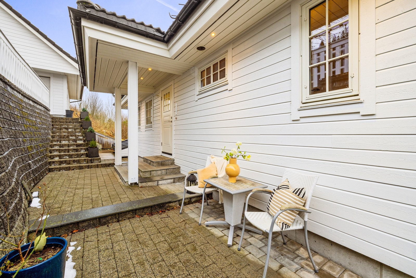 Hovedinngang med plass til sittugruppe. Opp trappen er garasjen og innkjørsel Galleribilde