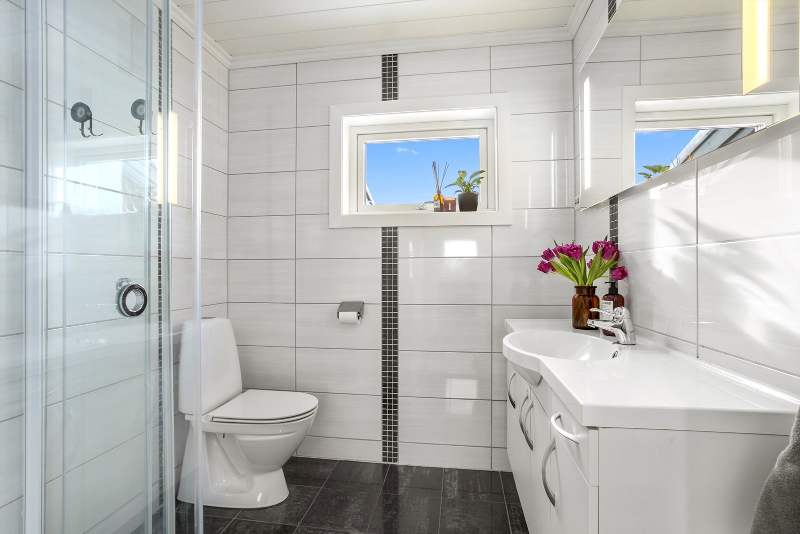 Pent baderom med flislagte overflater, gulvvarme og mekanisk avtrekk. Galleribilde