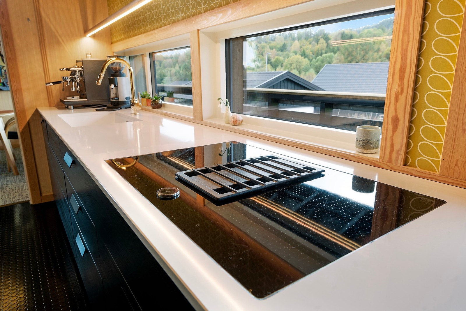 Her er stekeovn, oppvaskmaskin og platetopp med innebygget ventilator integrert på kjøkkenet Galleribilde