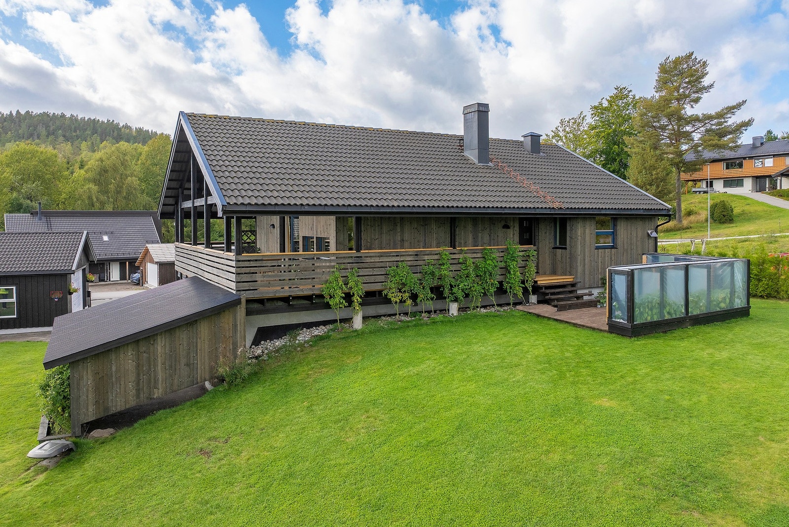 Verandaen strekker seg langs 3 av husets sider og gir deg tilgang til markterrasse og hagen Galleribilde