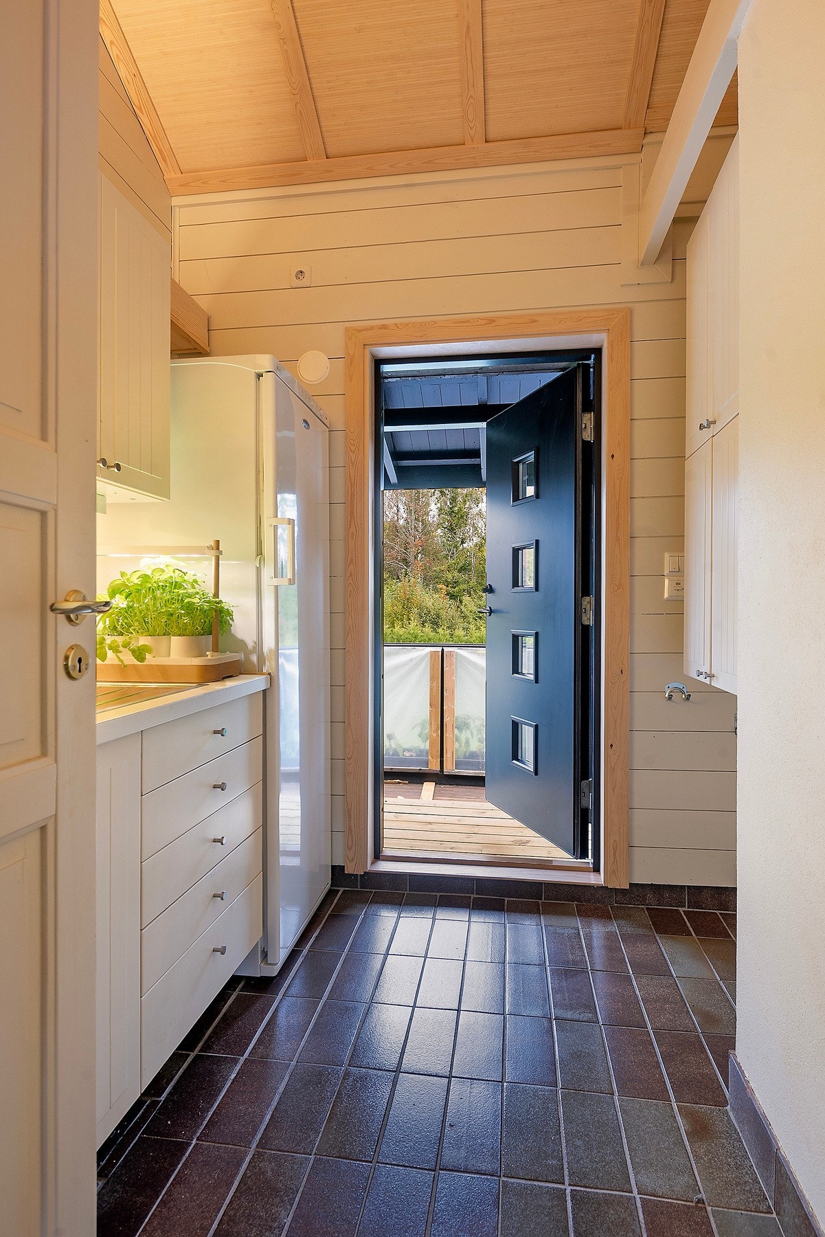 Vaskerommet er flislagt med varmekabler i gulvet, og har dør ut til veranda og hagen Galleribilde