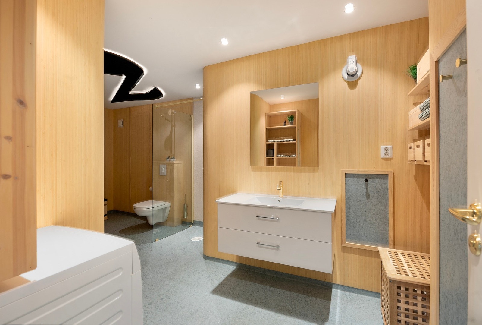 Romslig bad med gulvvarme, vegghengt toalett, regndusj og oppbevaring i servantinnredning, toalett Galleribilde