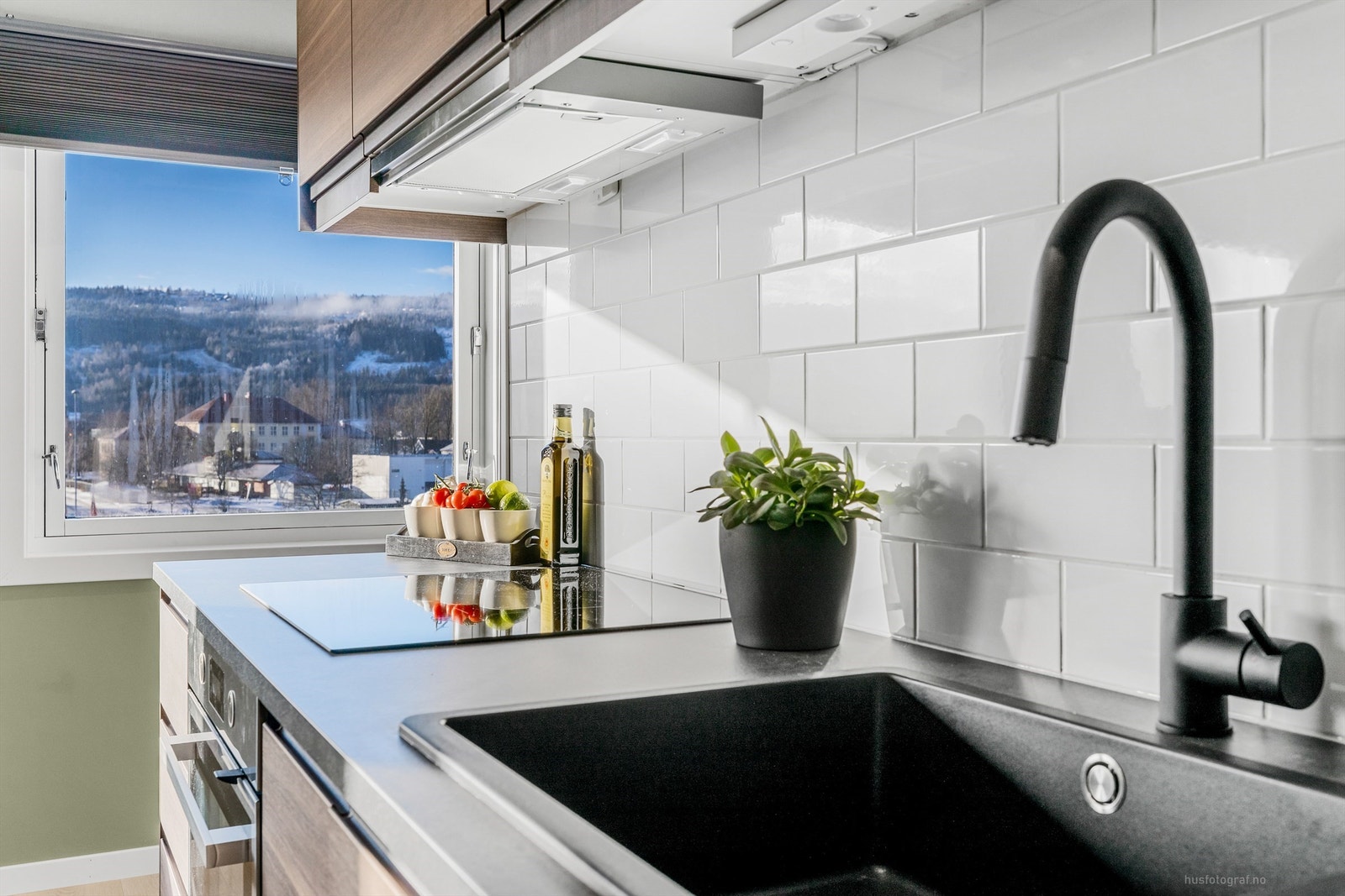 Kjøkkenet har moderne detaljer som sort blandebatteri og integrert platetopp med god arbeidsplass. Galleribilde