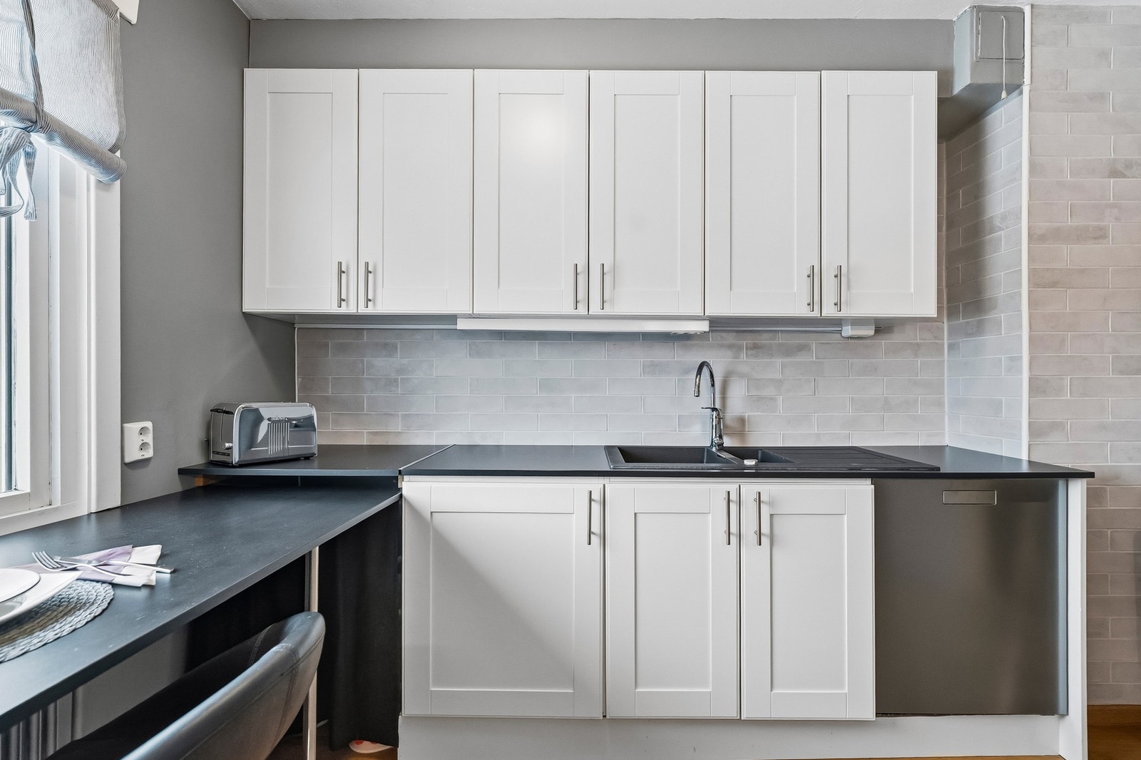 Lyst og praktisk kjøkken med god skapplass, arbeidsbenk og spiseplass Galleribilde