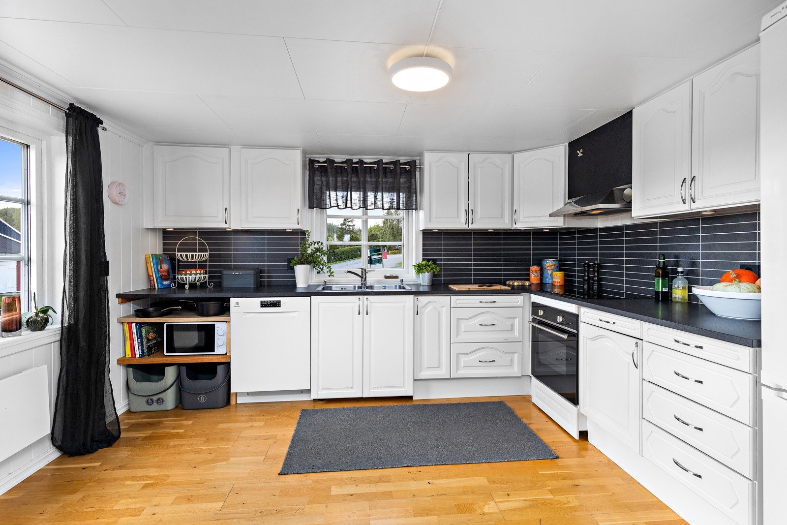 Kjøkken med takhøye overskap og laminat benkeplate. Galleribilde