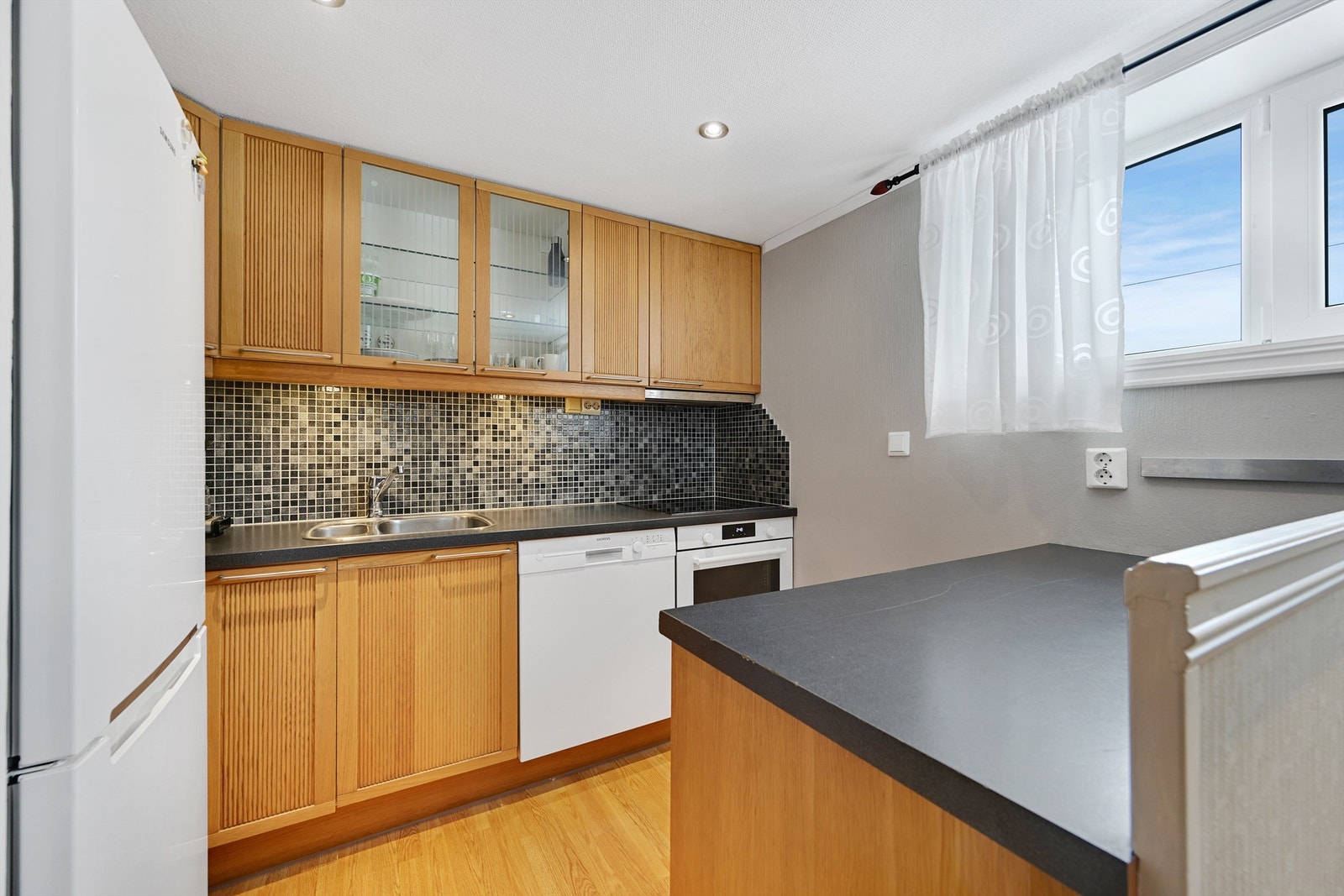 Kjøkken i hybel med integrerte hvitevarer Galleribilde