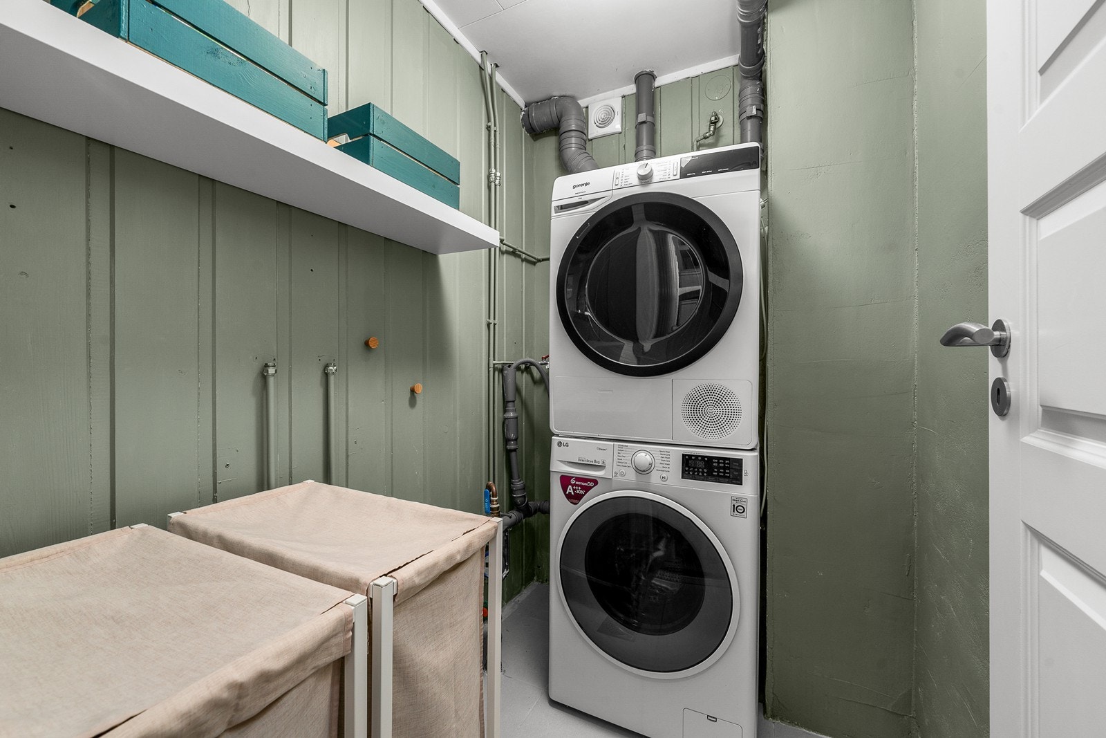 Separat vaskerom med flislagt gulv, varmekabler og opplegg for vaskemaskin. Galleribilde