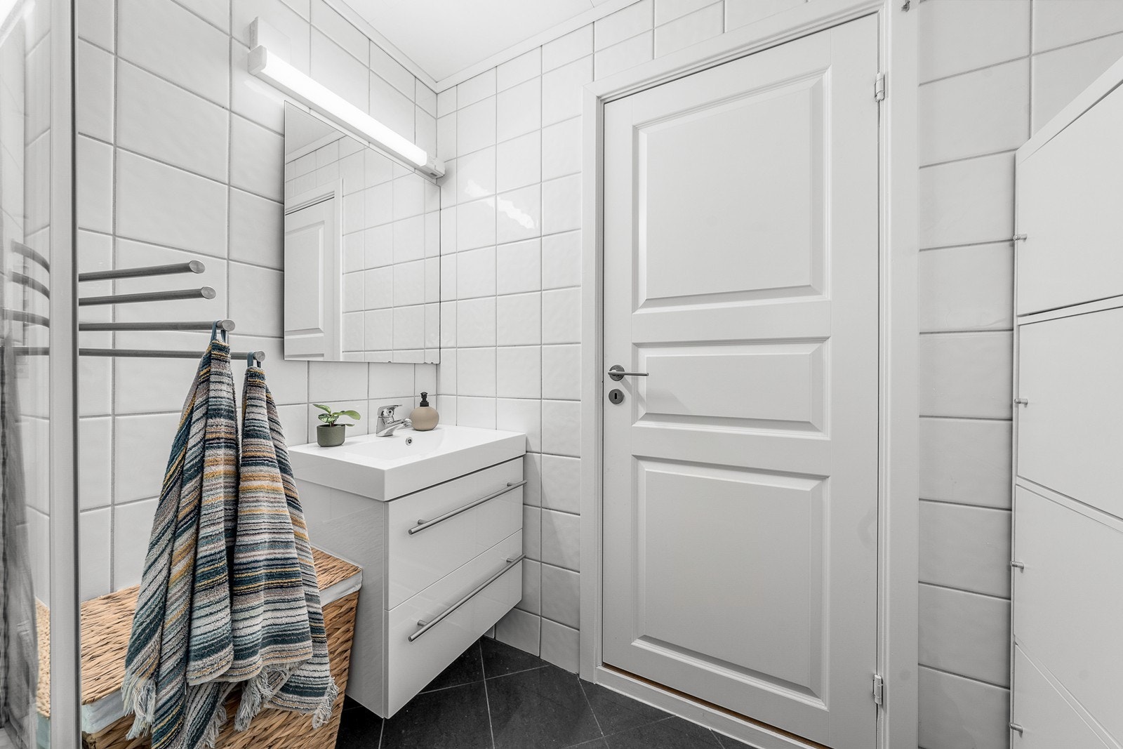 Badet er utstyrt med servantinnredning, toalett og dusjkabinett. Galleribilde