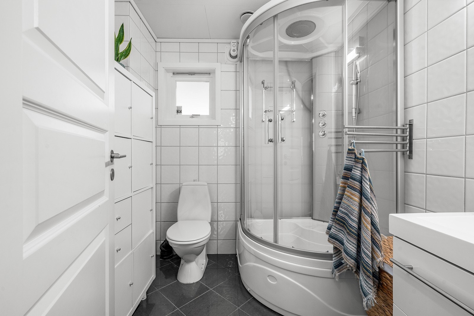 Praktisk bad i hovedetasjen med flislagte overflater og elektriske varmekabler i gulvet. Galleribilde