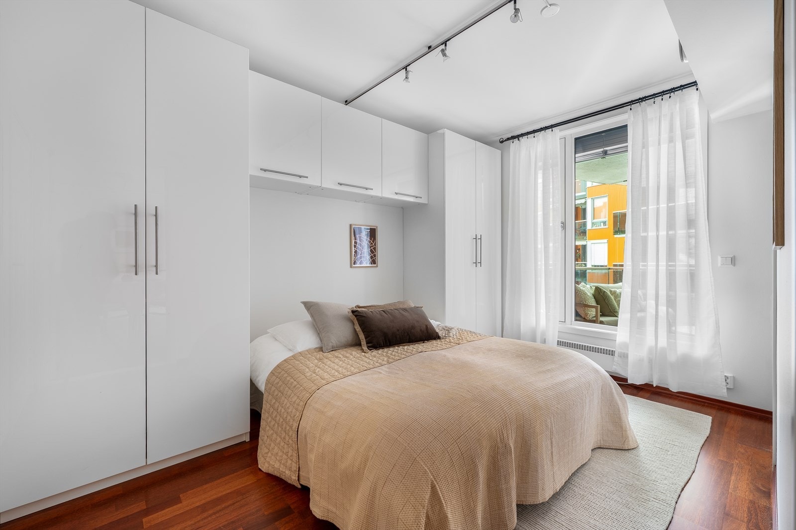 Et lunt og behagelig soverom med vindu vendt mot tilhørende balkong og et rolig atrium. Galleribilde