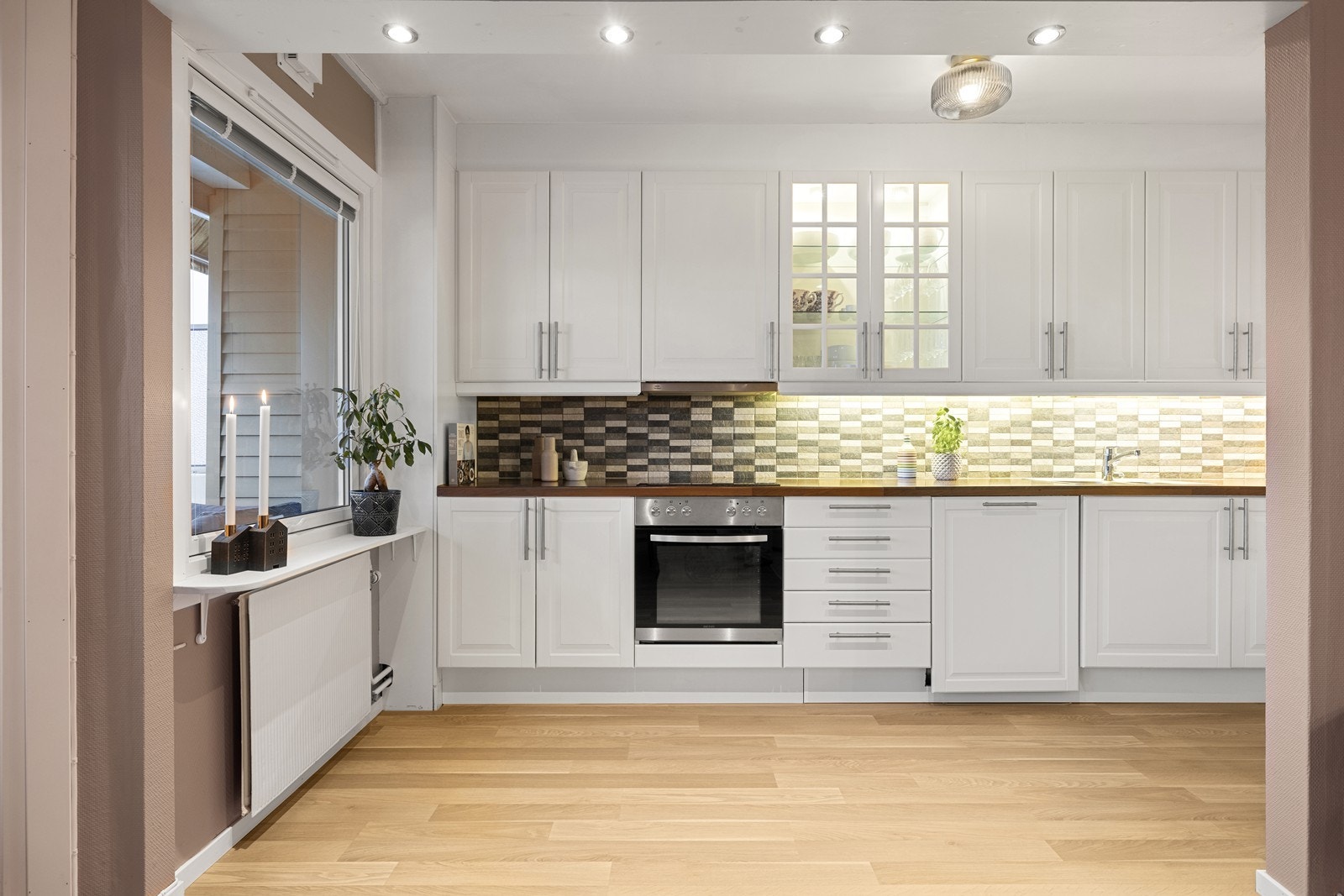 Kjøkkeninnredningen har profilerte, fabrikklakkerte fronter og godt med skapplass. Galleribilde