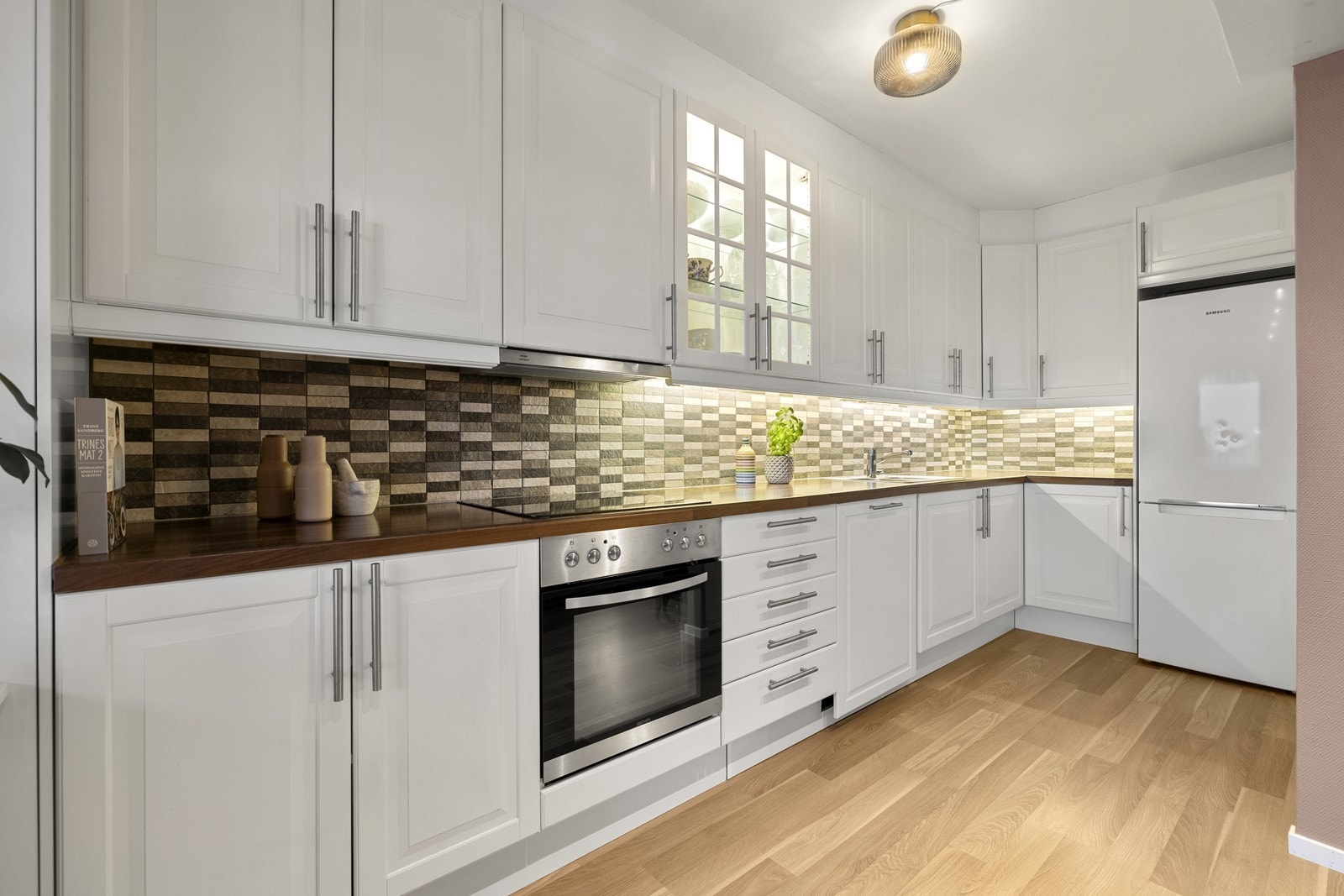 Kjøkkenet er utstyrt med integrert stekeovn, koketopp og en ny oppvaskmaskin fra 2025. Galleribilde