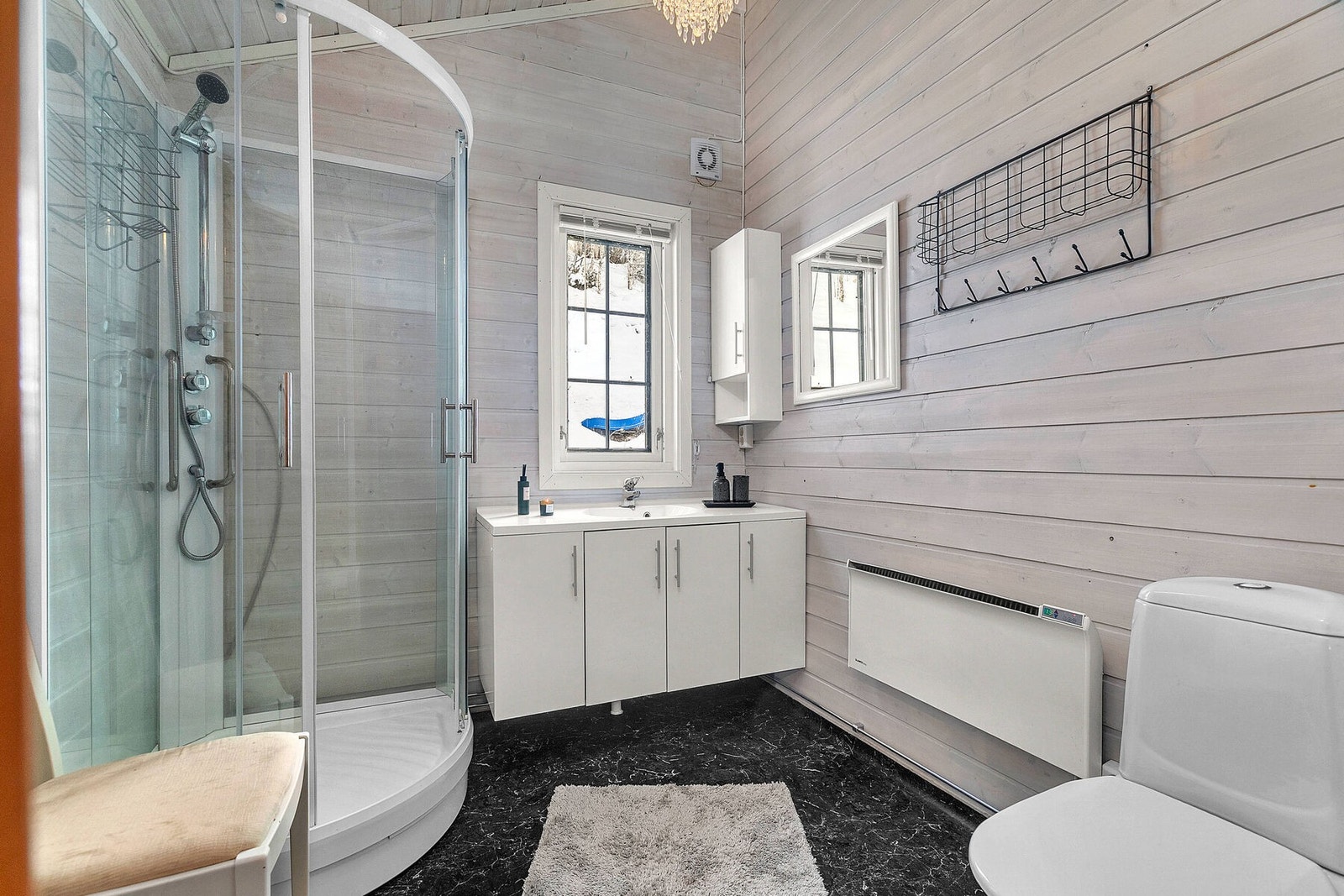 Bad med dusjkabinett, pen innredning og opplegg for vaskemaskin Galleribilde