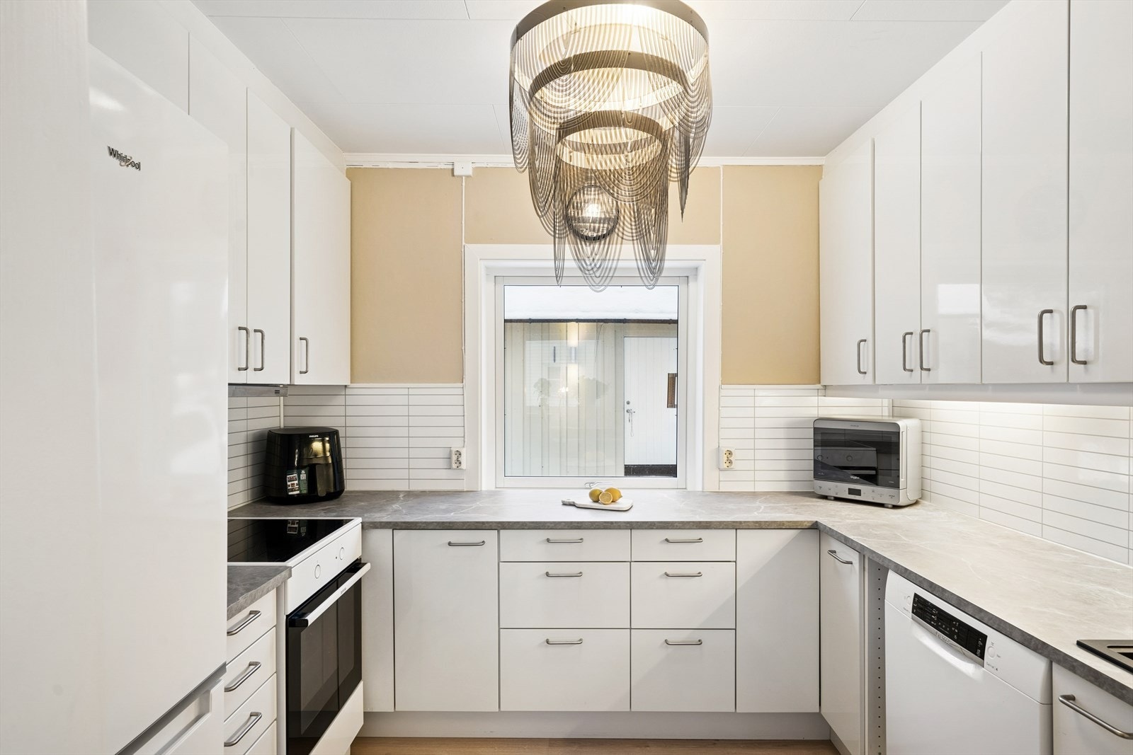 Kjøkkeninnredningen har lyse, glatte fronter og benkeplate av laminat med nedfelt vaskekum. Galleribilde