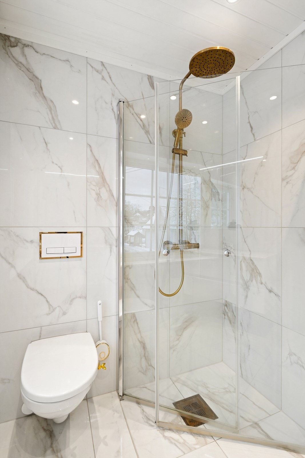 Badet er innredet med vegghengt toalett, servant nedfelt i møbel og dusjhjørne med svingbare glassdører. Det er installert fuktstyrt elektrisk vifte for effektiv ventilasjon. Galleribilde