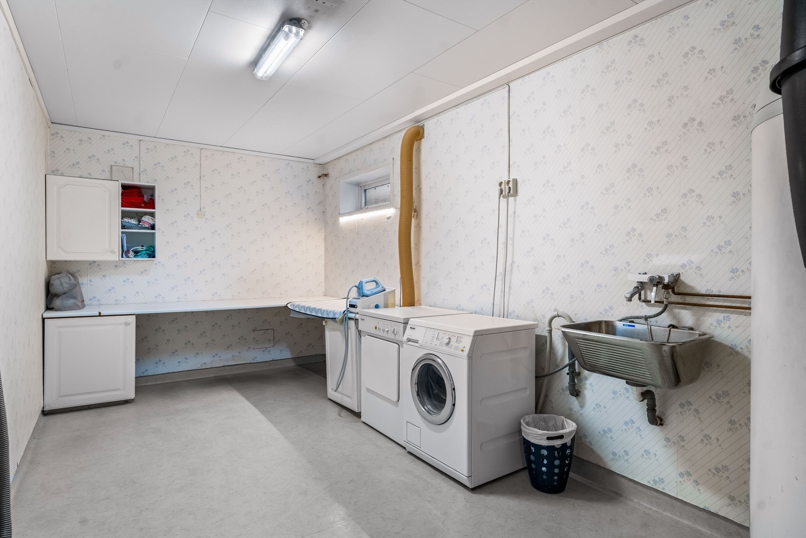 Vaskerommet er utstyrt med med skapinnredning, utslagskum og opplegg for vaskemaskin. Det ble registrert fuktforskjeller i gulv rundt varmtvannsbereder og sluk, og rommet er totalt sett av eldre standard. Takstmann gir vaskerommet TG3. Galleribilde