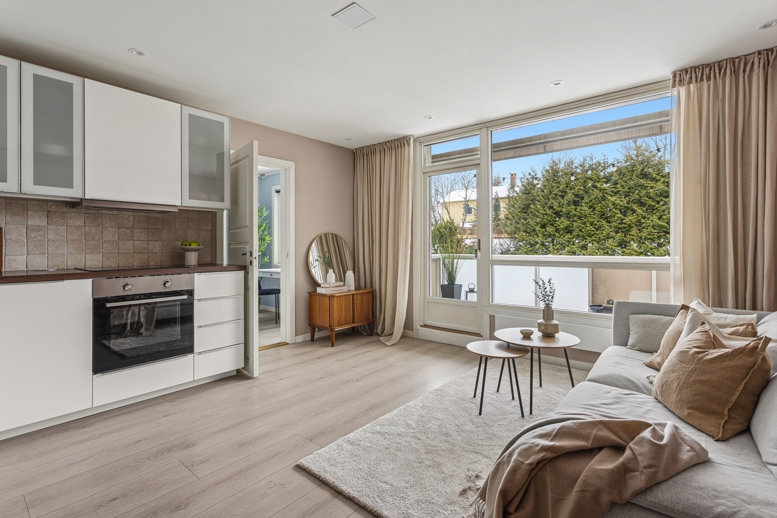 Et sosialt rom med kjøkken i åpen løsning mot stuen. Galleribilde