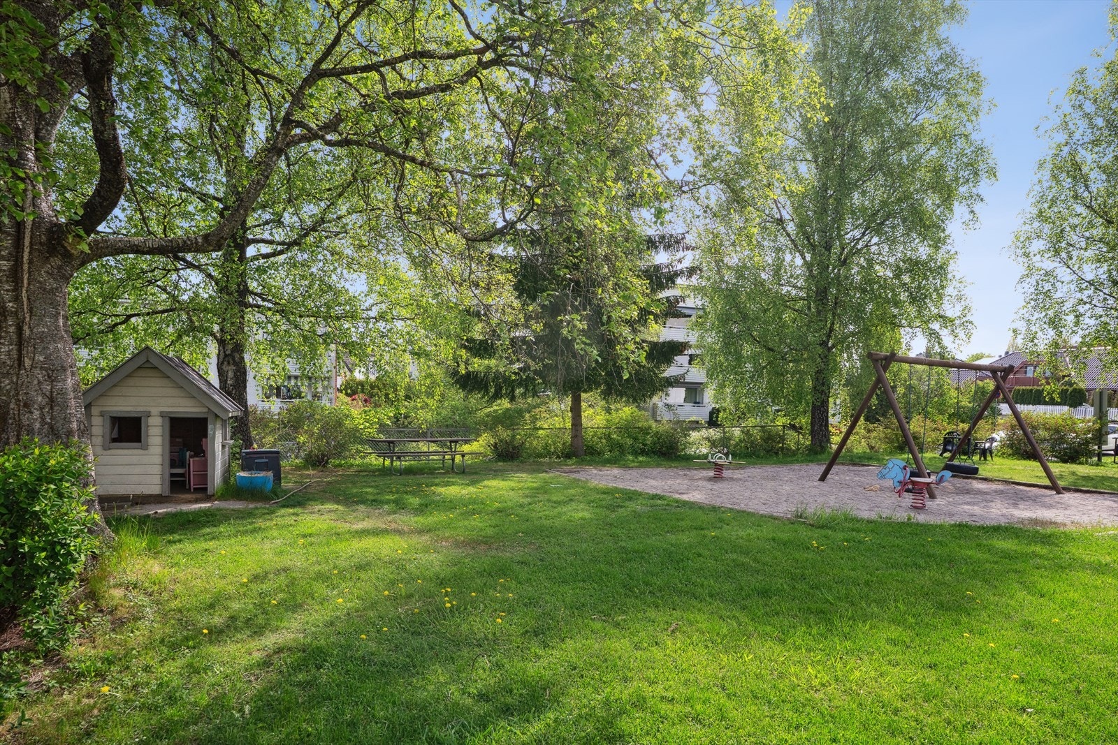 Meget idyllisk felles tomt opparbeidet med asfalterte intern veier, friområde med benker og lekeapparater, gressplen, hekker, ulike prydtrær og busker. Galleribilde