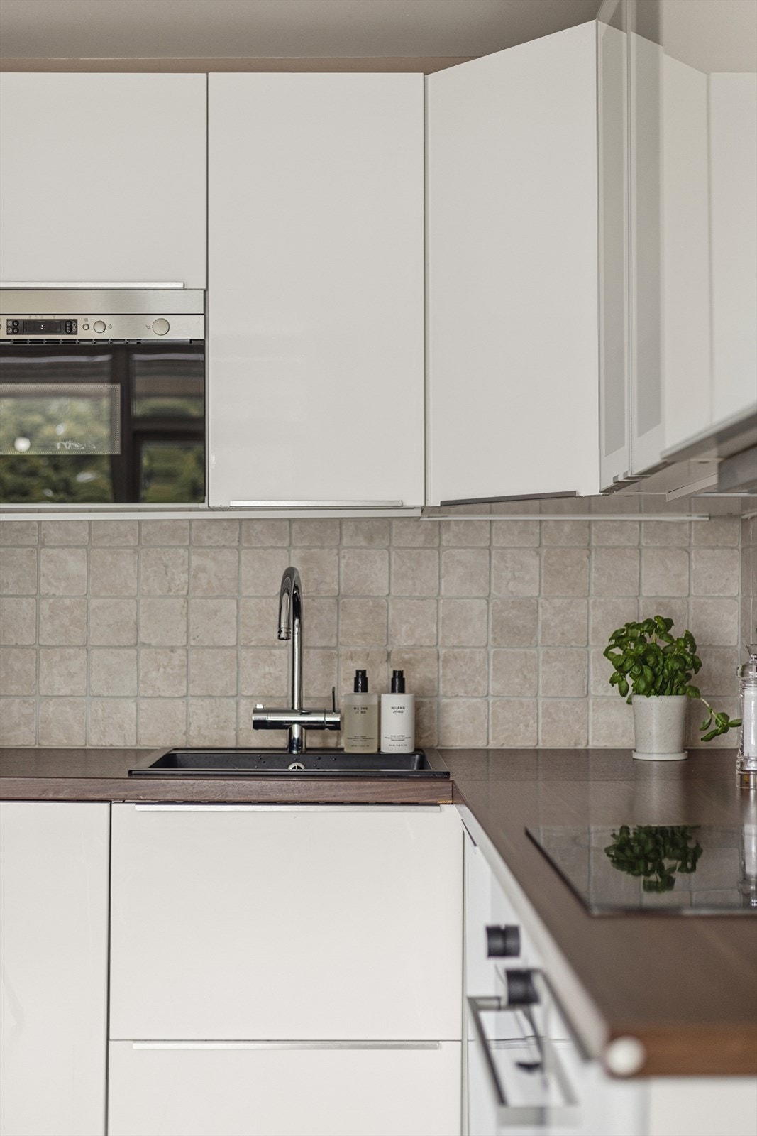 Det er fliser og belysning over benkeplaten. Integrerte hvitevarer som micro, platetopp, stekeovn og oppvaskmaskin. Galleribilde