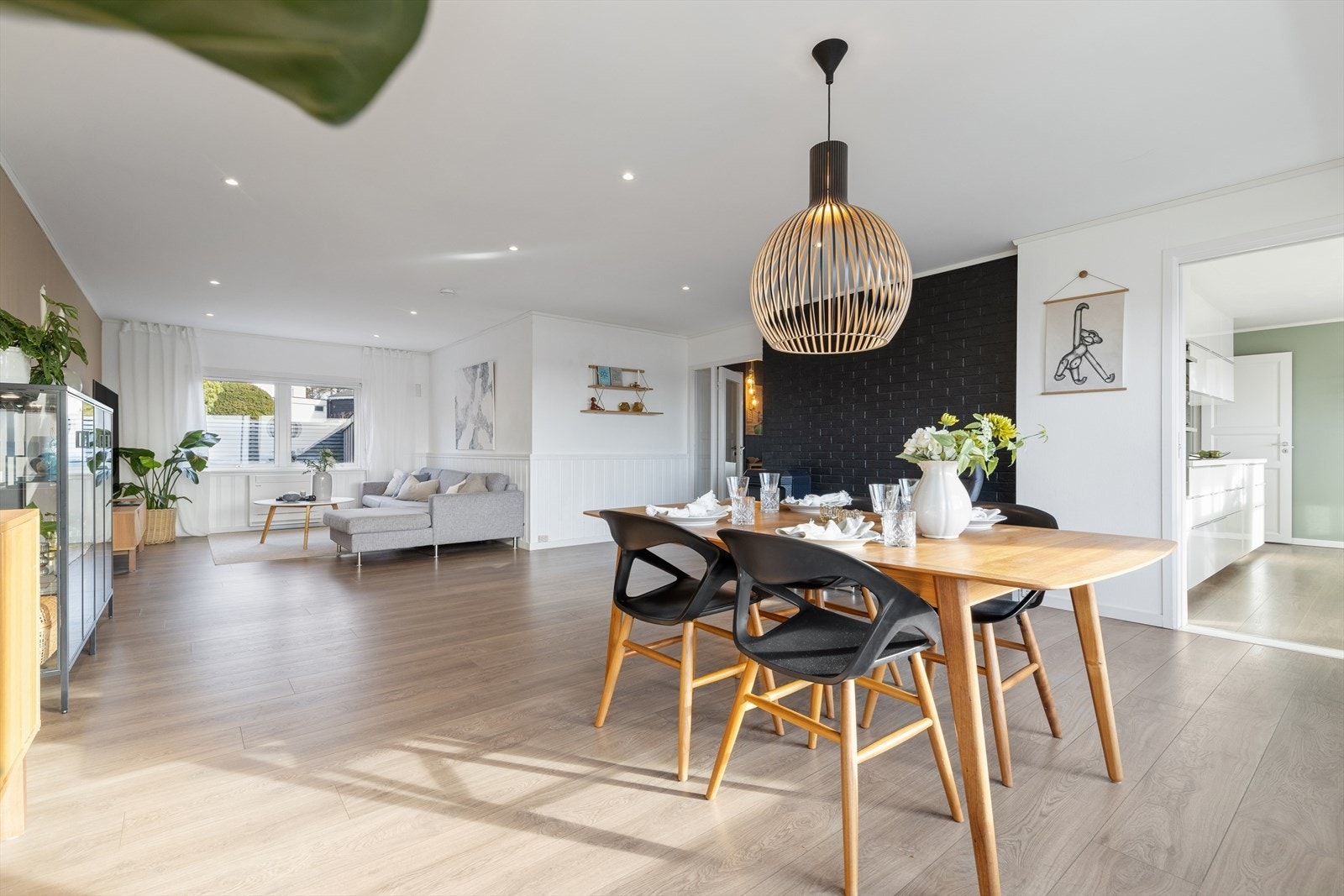 Rommet har god plass til både en romslig sofagruppe og et stort spisebord, noe som gjør det enkelt å kombinere avslapning og sosiale måltider og direkte tilkomst til kjøkken. Galleribilde