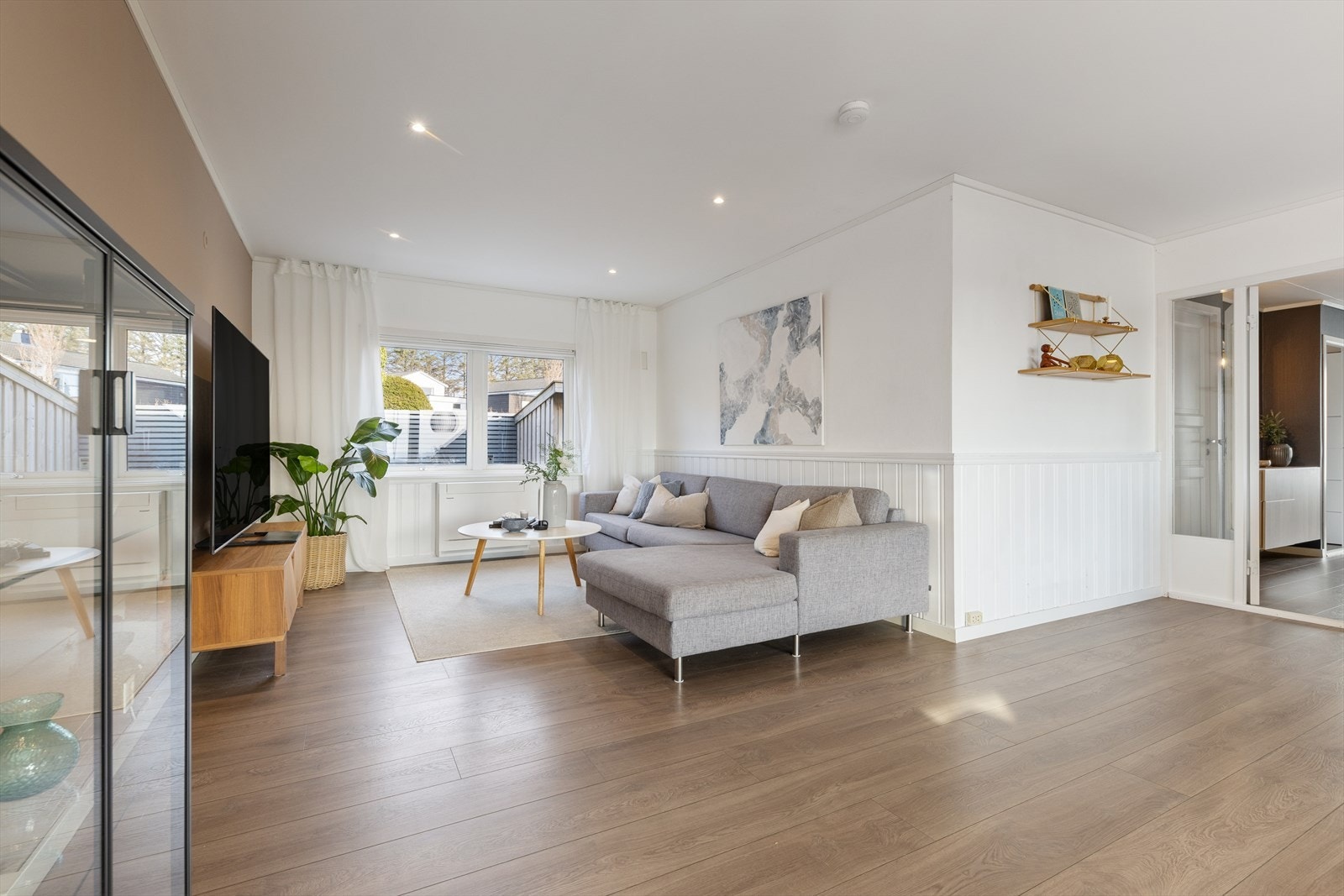 Stuen er lys og romslig, med spotter i himlingen som gir en moderne og behagelig belysning. Galleribilde