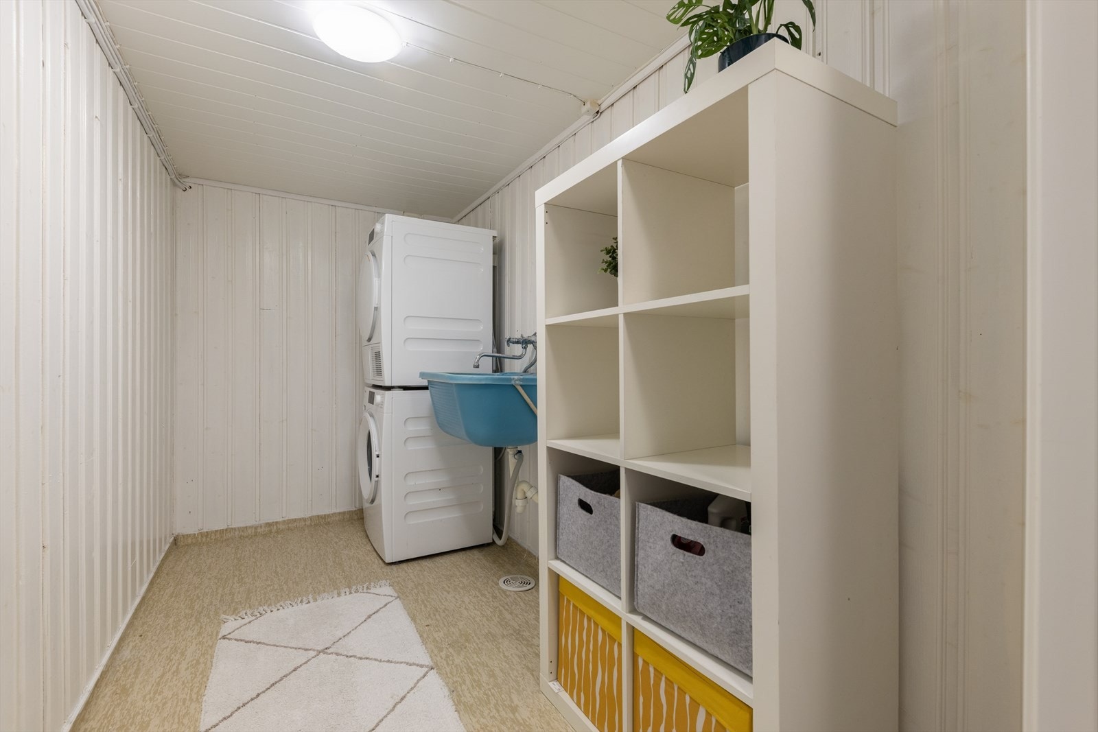 Praktisk vaskerom med utslagsvask. God plass til både vaskemaskin og tørketrommel samt hyllestystem. Galleribilde