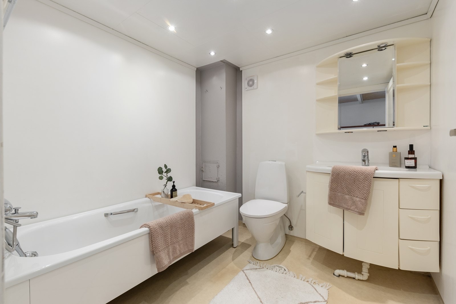 Badet i underetasjen har vinylbelegg på gulvet og malte plater på veggene. Innredet med servant nedfelt i baderomsinnredning, toalett og badekar Galleribilde