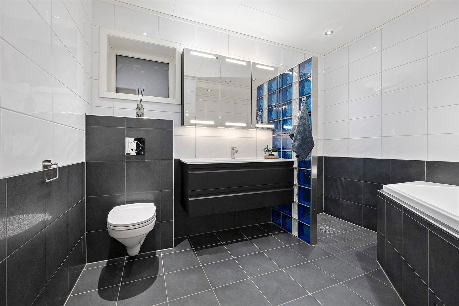 Stiltrent bad i underetasjen med flislagt gulv med varmekabler, fliser på vegger og himlingsplater i taket. Galleribilde