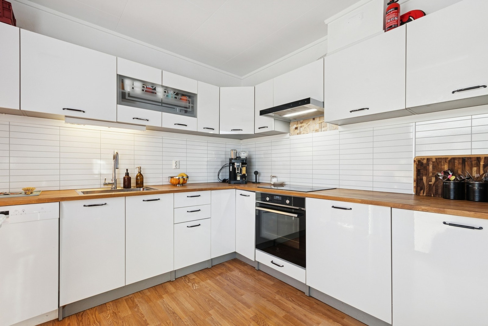 Kitchenboard over benk, integrerte hvitevarer og opplegg for oppvaskmaskin. Waterguard installert under benk. Galleribilde