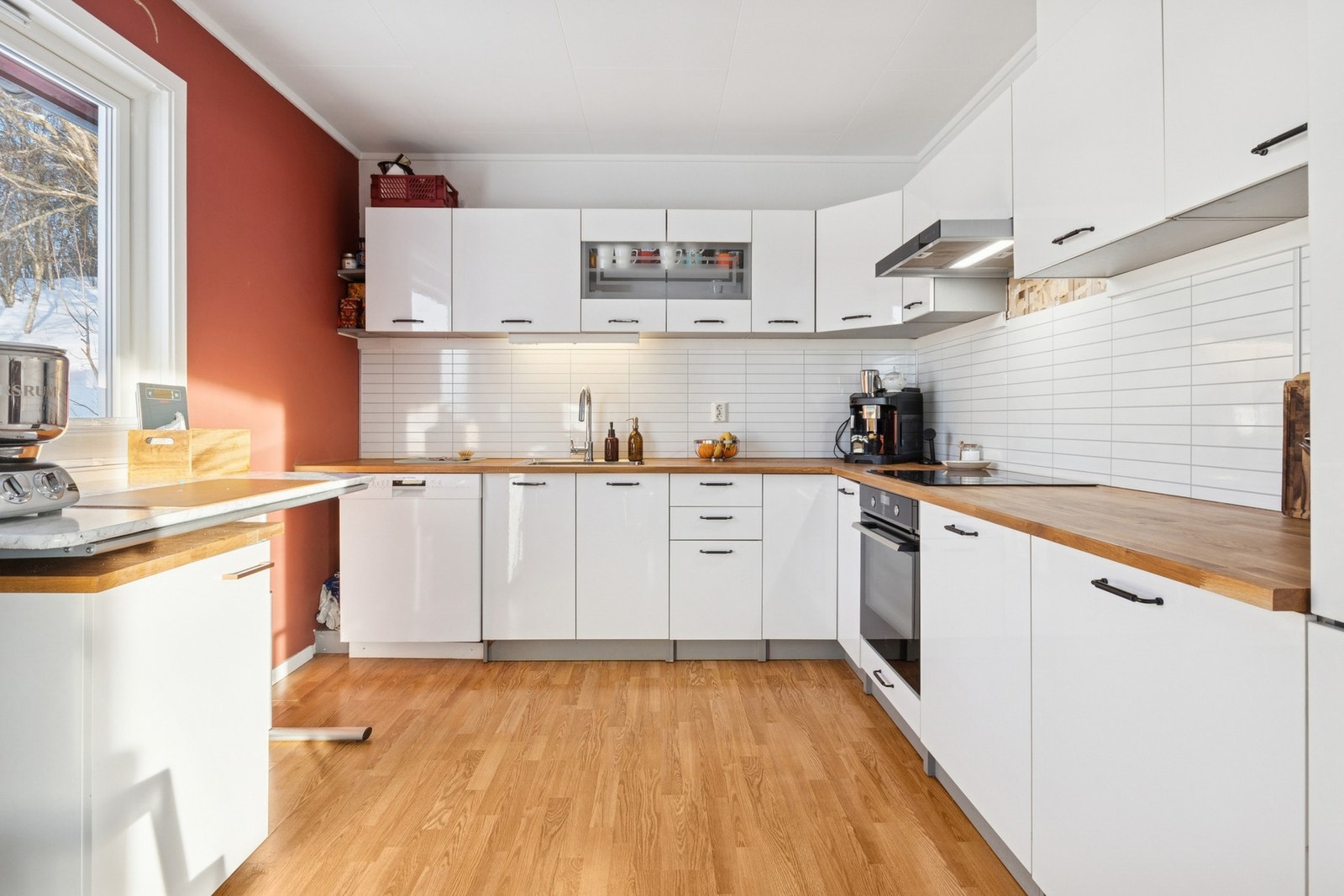 Moderne kjøkken med glatte fronter, integrerte hvitevarer og godt med skap- og benkeplass. Galleribilde