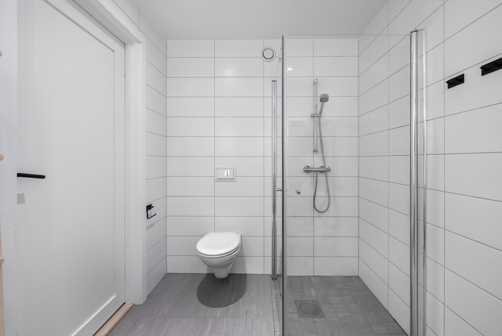 Også her er det flislagte overflater, gulvvarme og et romslig dusjhjørne. Galleribilde