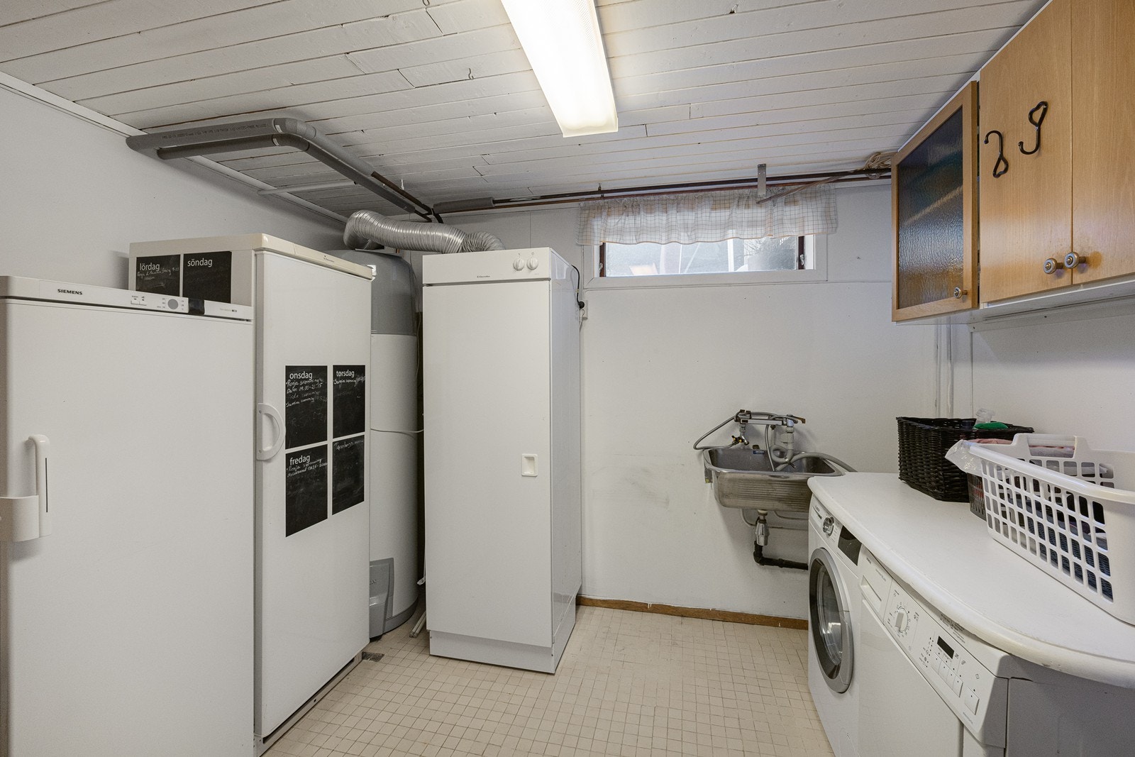 Vaskerommet er godt utstyrt med overskap og benk, samt utslagsvask og opplegg for vaskemaskin i underkant av benkeløsningen. Galleribilde