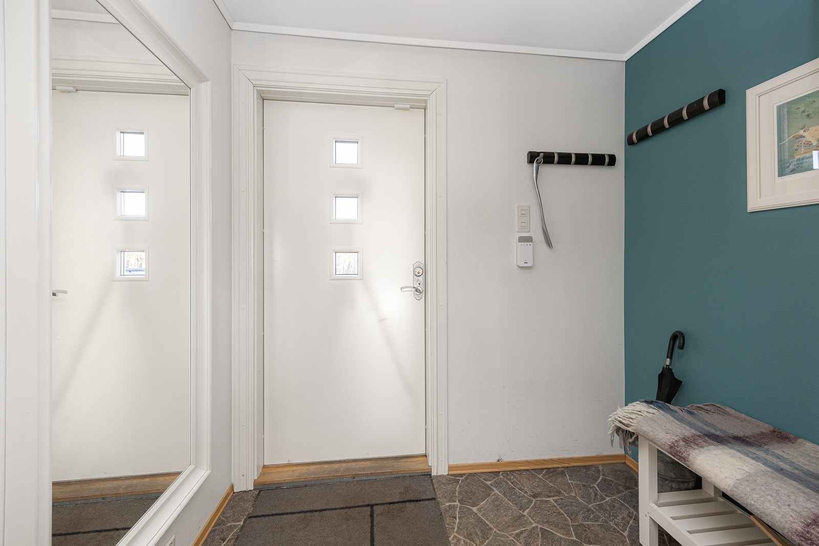 Entréen er romslig og har åpen garderobeløsning med knaggrekker og skohyller. Galleribilde