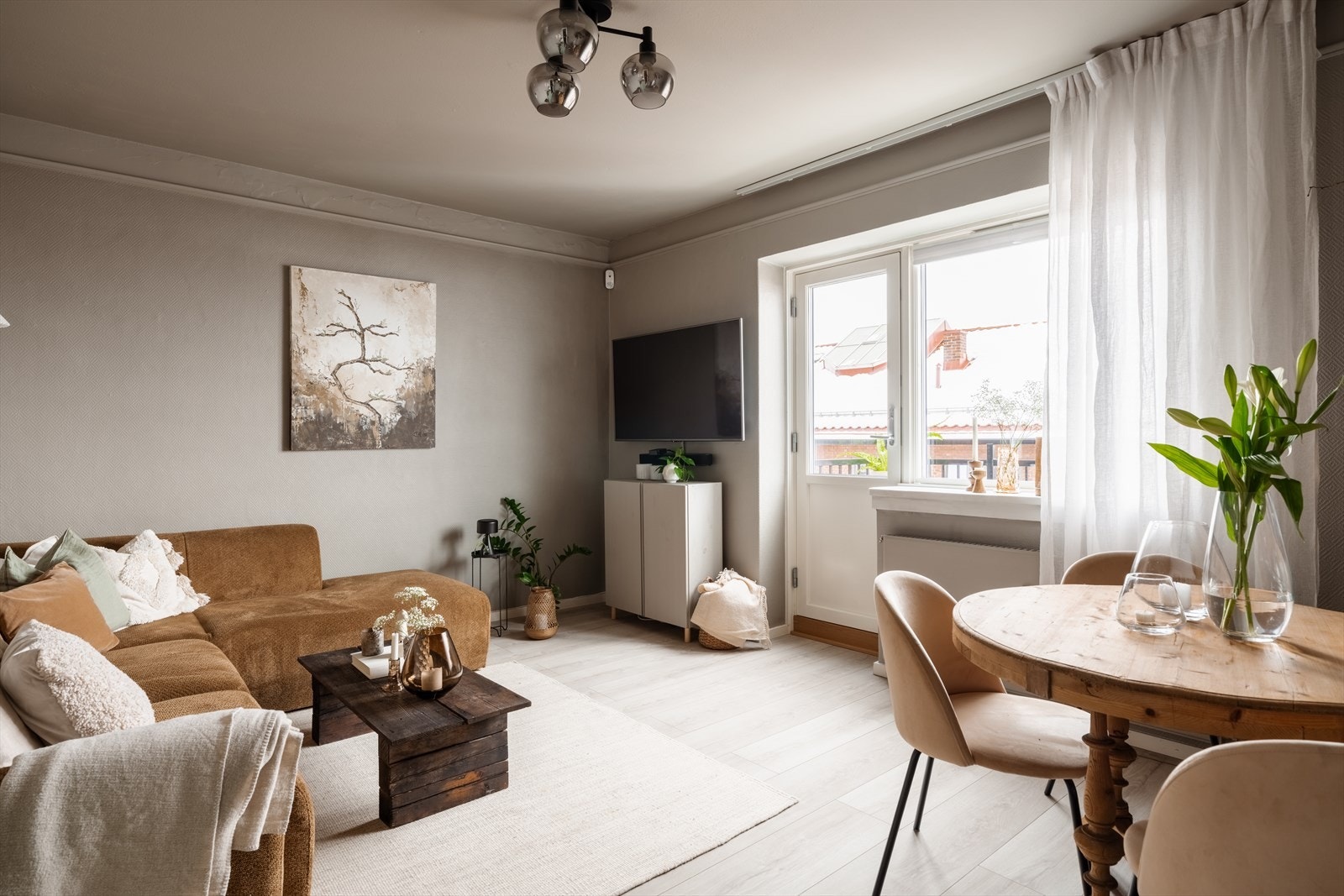 Innbydende og koselig stue med god plass til både sofagruppe, tv-bord og spisebord Galleribilde