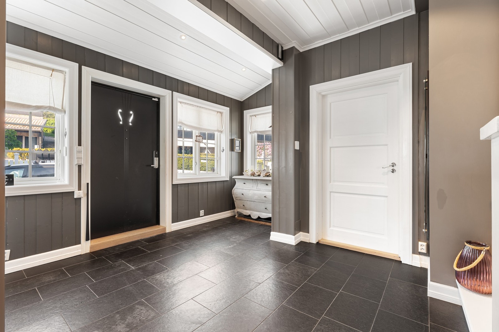 De flislagte gulvflatene, komplett med varmekabler, gir en praktisk løsning for rengjøring når våte sko og yttertøy tas av Galleribilde