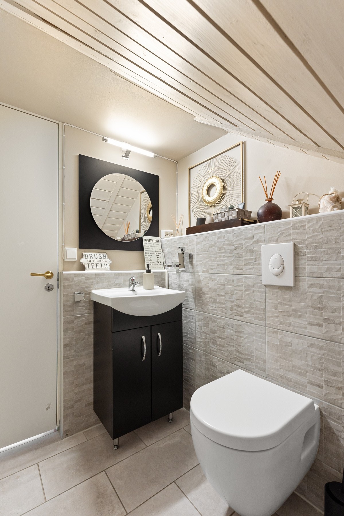 Toalettrommet har vegghengt toalett og servant med skap under Galleribilde